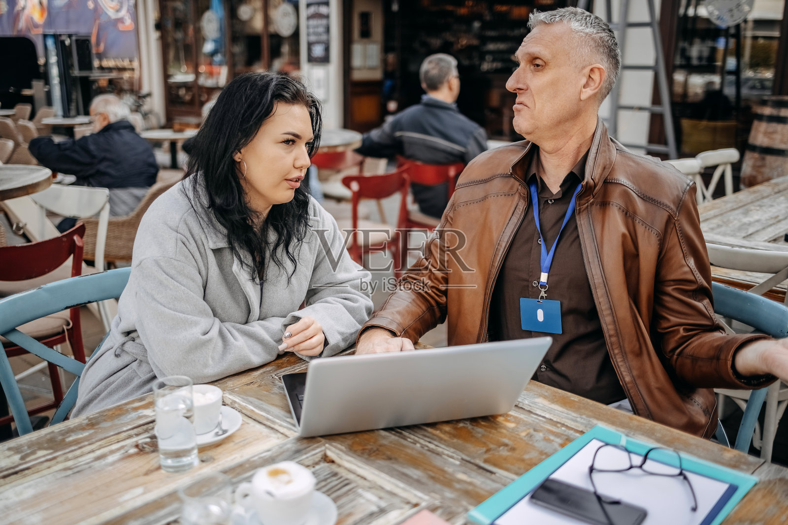 保险代理人坐在咖啡馆里用笔记本电脑向客户推销保险照片摄影图片