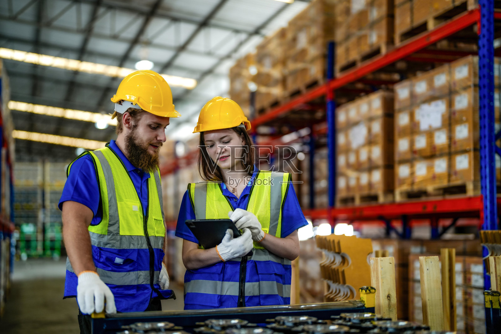 检查和检验装运的金属机械零件。男工人和女工人检查商店工厂。工业工厂仓库。存放机械和车辆备件的仓库。照片摄影图片