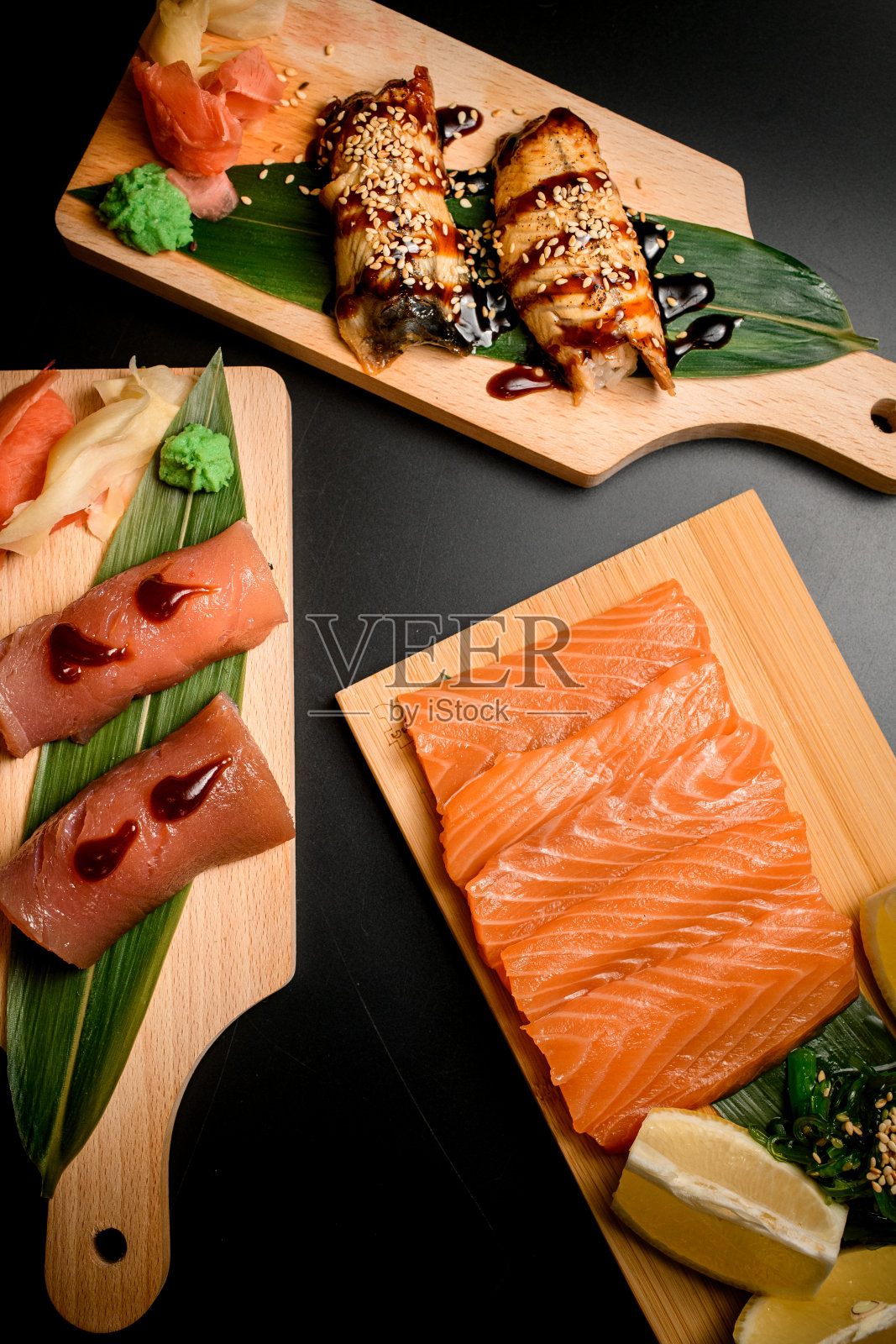 寿司和卷放在黑色背景的木板上照片摄影图片