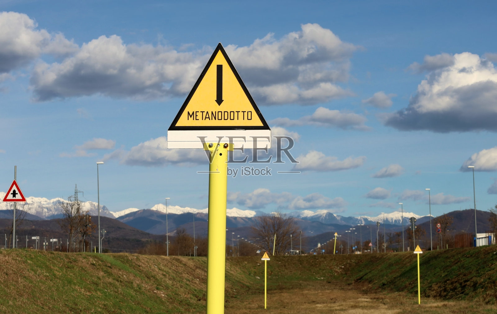 Metanodotto，天然气管道英文。公共黄色三角警告标志。背景景观照片摄影图片