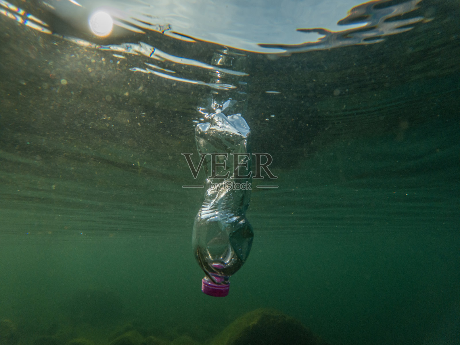 水下塑料污染，瓶装水漂浮在水中照片摄影图片