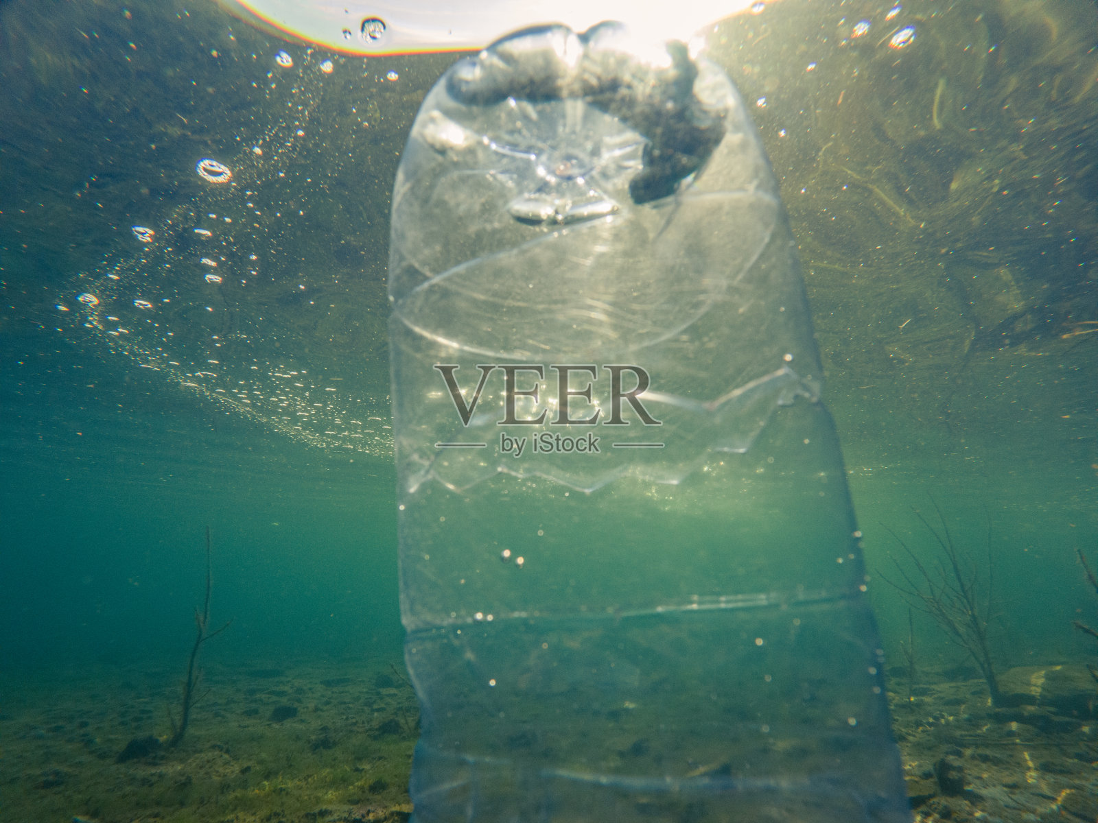 水下塑料污染，瓶装水漂浮在水中照片摄影图片