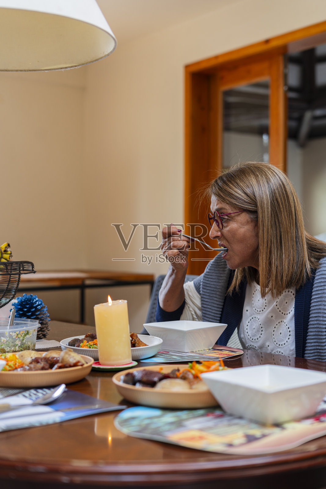 一位拉丁妇女在养老院里负责照顾她，吃着照顾她的人准备的美味午餐照片摄影图片