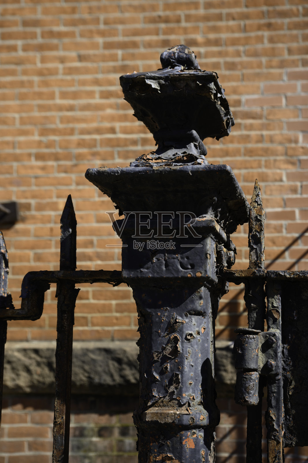 土质的金属栅栏杆在红砖墙前，特写照片摄影图片