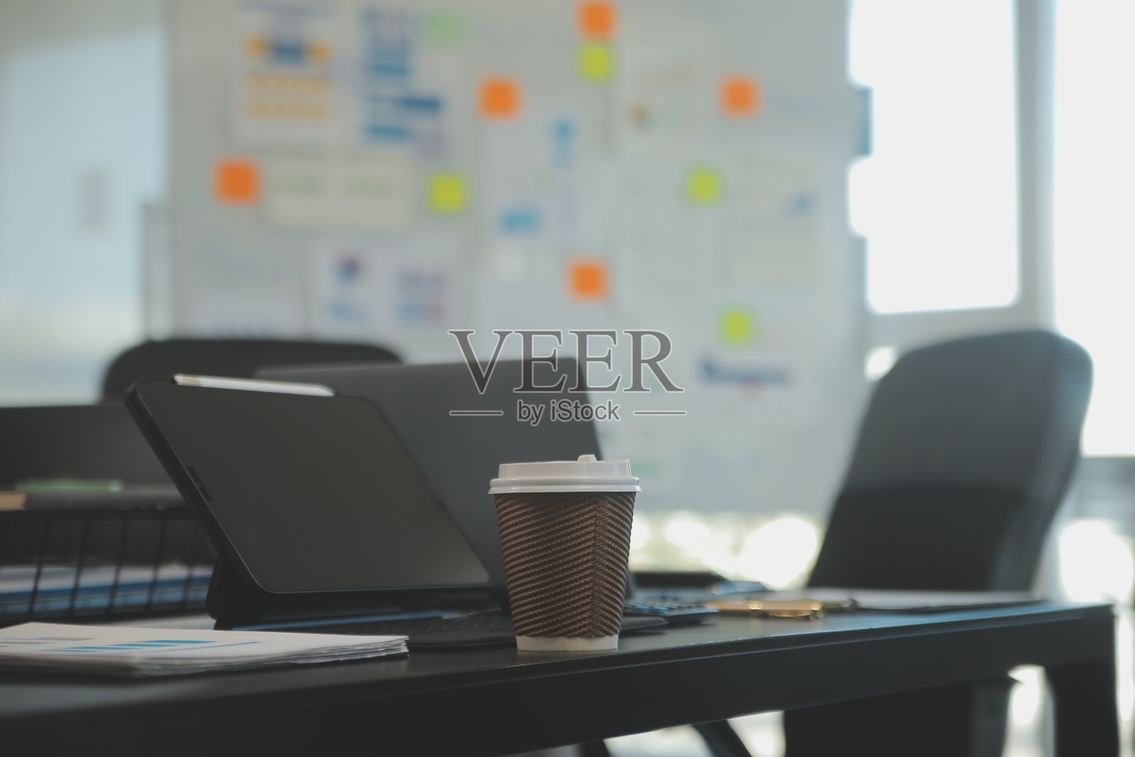 在开放式金融办公室的桌子上放一台笔记本电脑。照片摄影图片