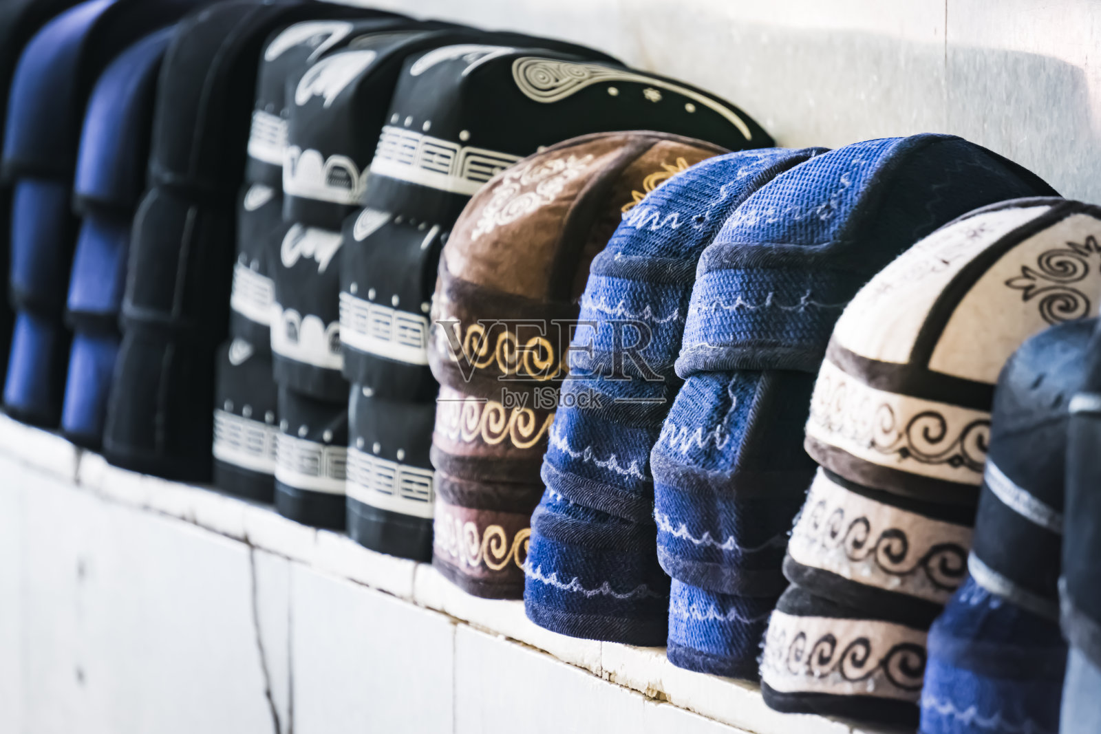 在乌兹别克斯坦撒马尔罕古城的集市上，人们戴着传统的头巾和无边便帽照片摄影图片