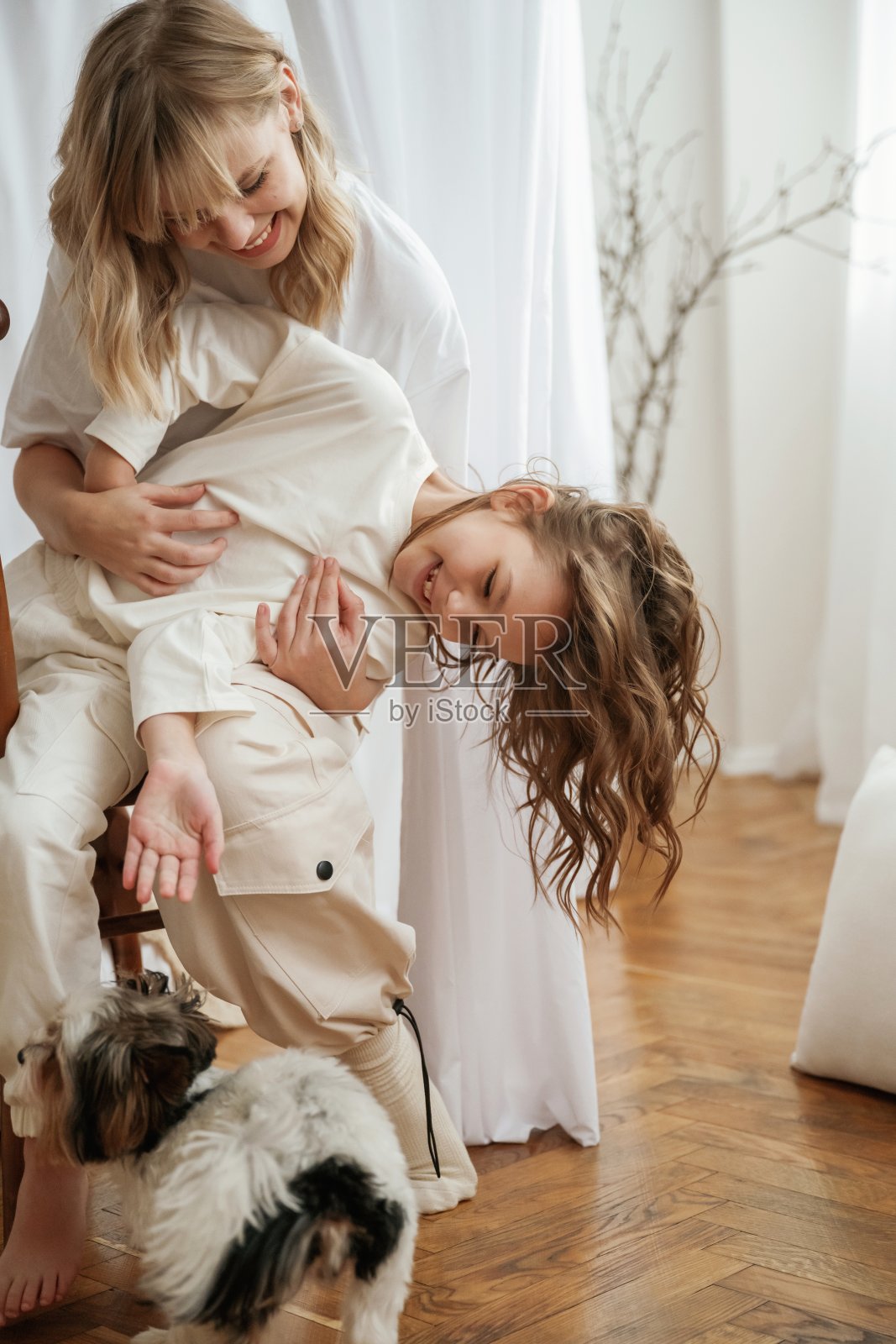 可爱的小狗。母亲和女儿一起在家照片摄影图片