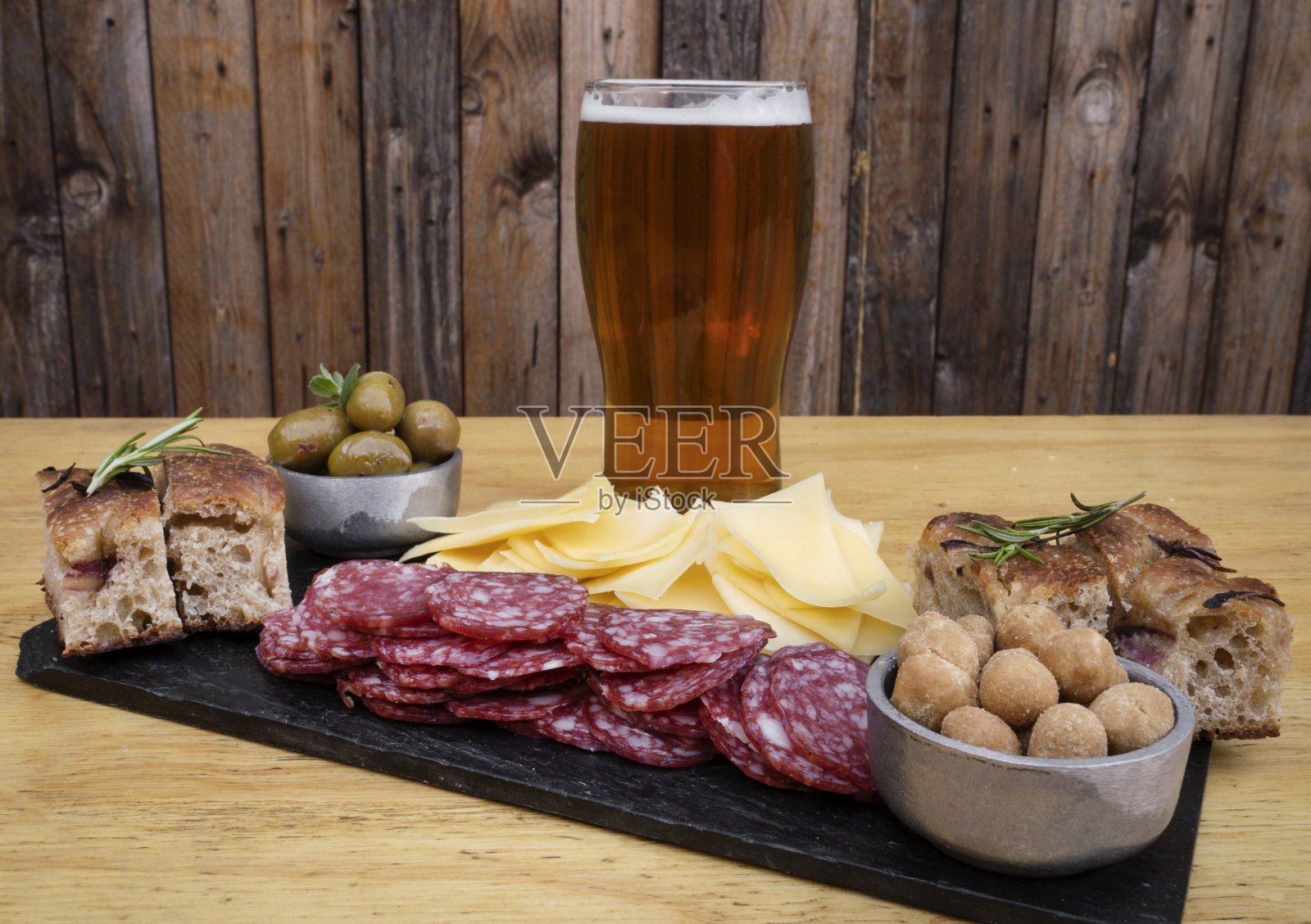 传统的阿根廷皮卡达配上一杯啤酒和木制背景照片摄影图片