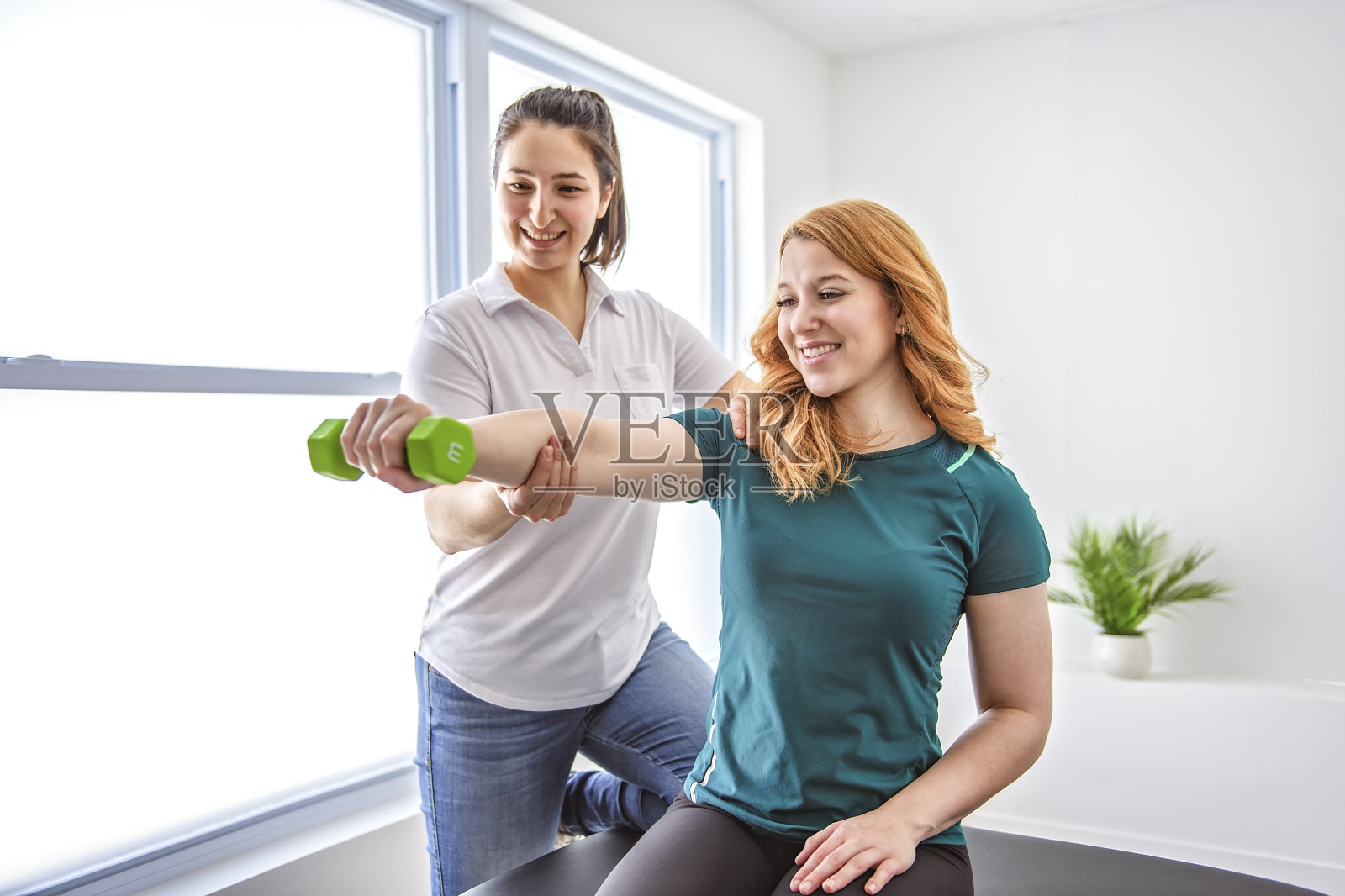 现代康复理疗在工作中与客户举哑铃照片摄影图片