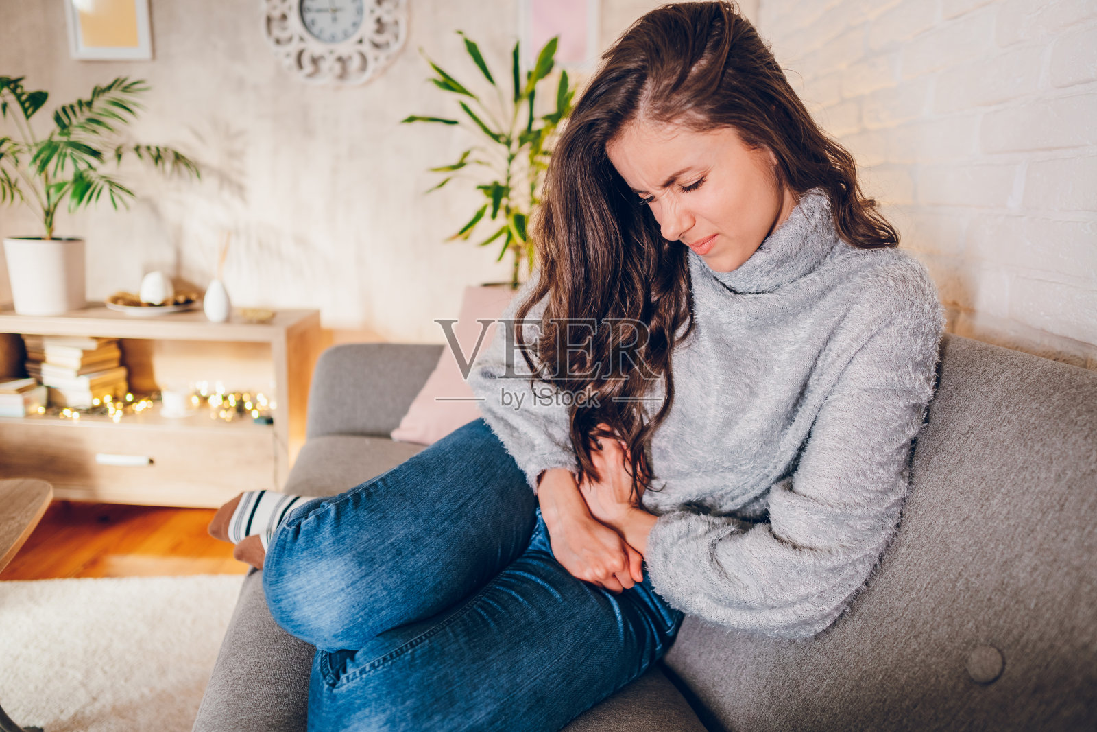 年轻女子在家里胃痛照片摄影图片