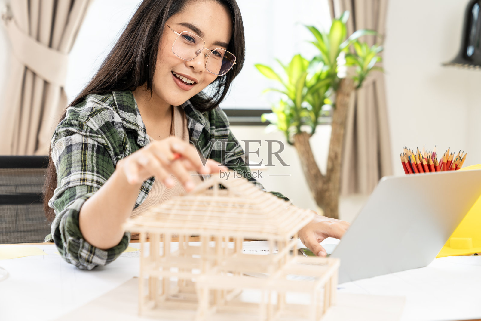 一位建筑师正在办公室里用房子的模型设计一个家照片摄影图片