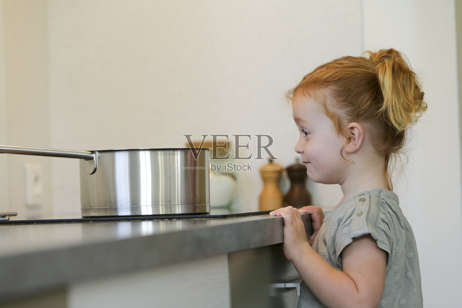 小女孩在厨房里拿着平底锅照片摄影图片