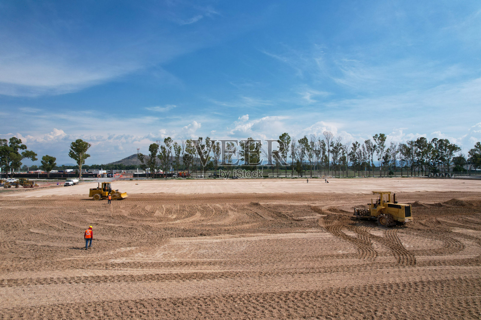 建筑工地视图。在地面监督挖掘机工作的工程师。照片摄影图片