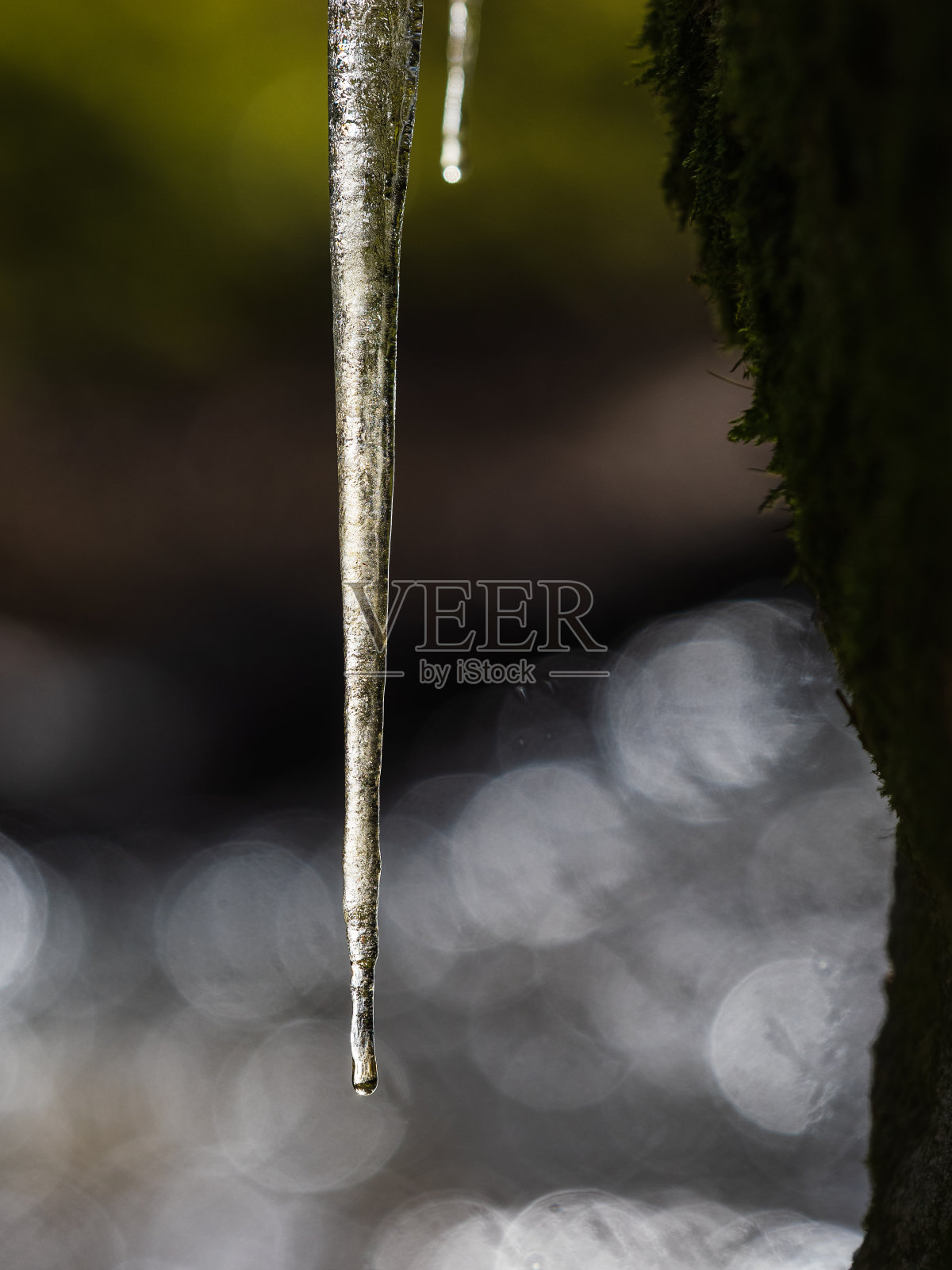 冬天，冰柱悬挂在瑞典闪闪发光的河流上照片摄影图片