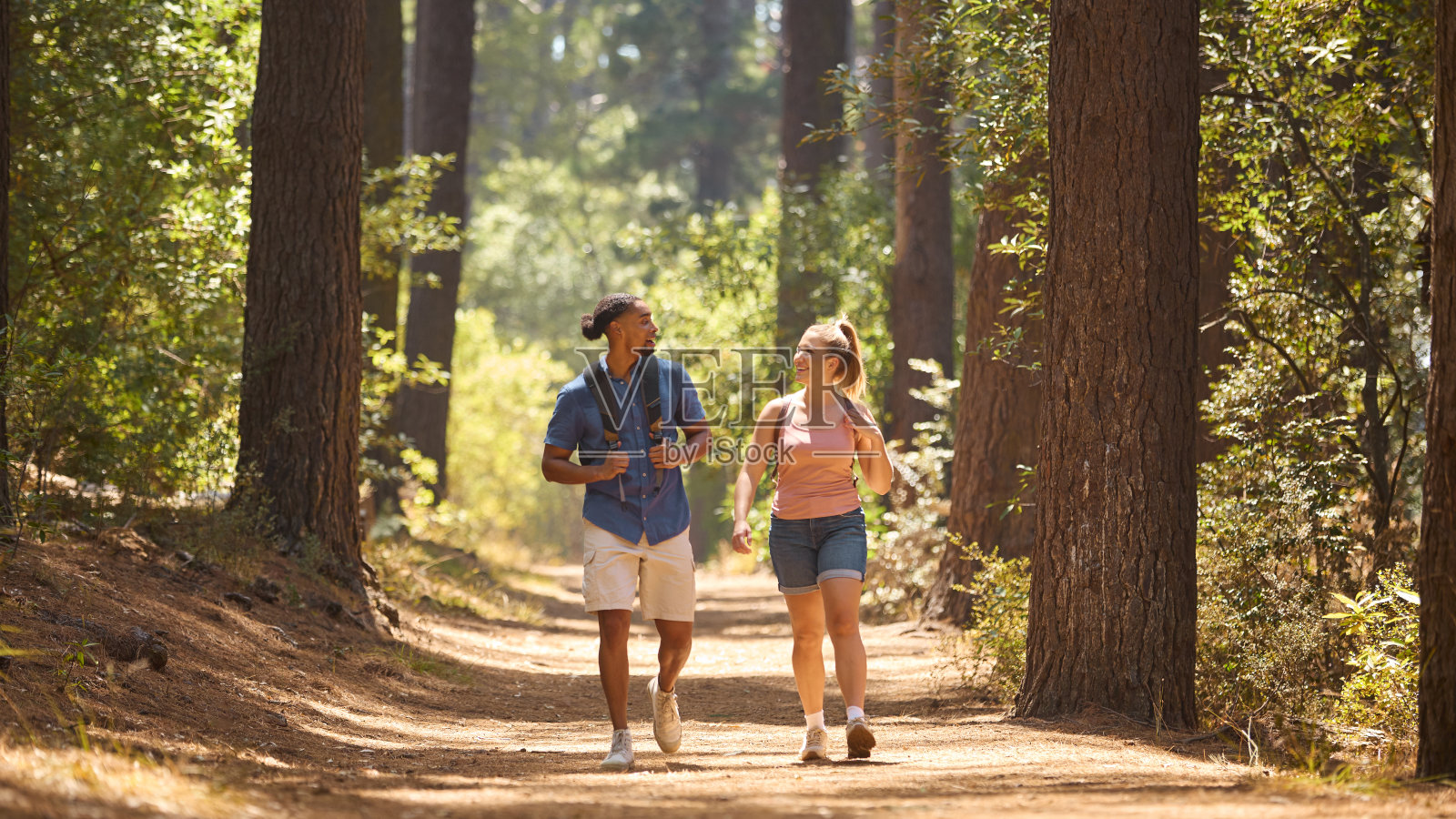 年轻夫妇背着背包沿着乡间小径徒步旅行照片摄影图片