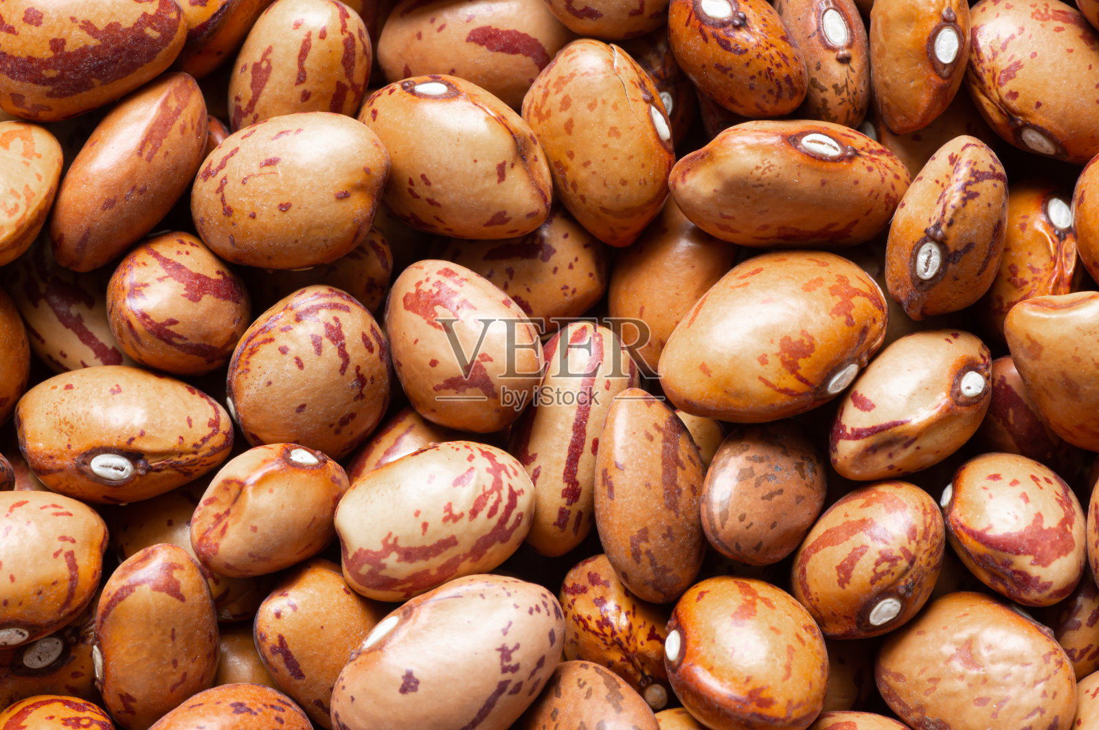 未煮熟的干罗马豆在碗或勺子在桌子上，堆豆类芸豆的概念照片摄影图片