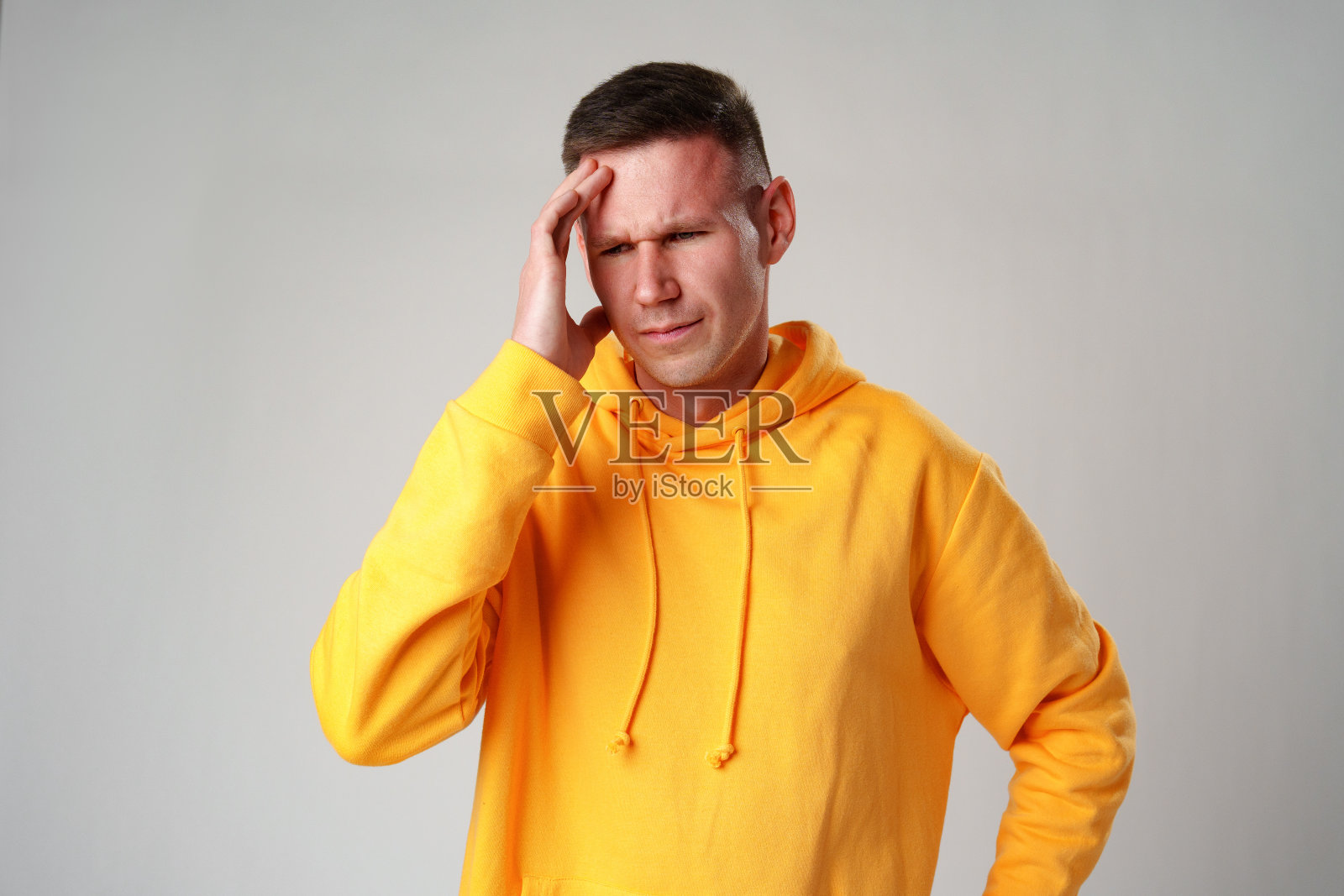 年轻男子在灰色背景下头痛照片摄影图片