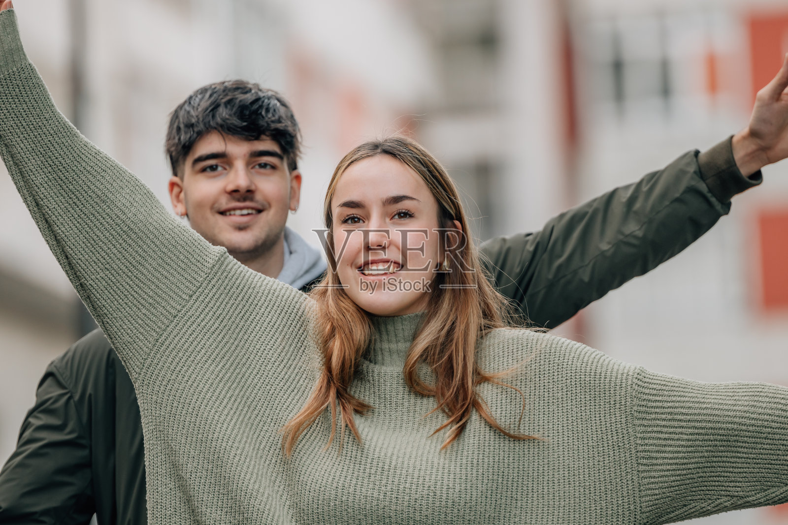 在街上手臂张开的快乐情侣照片摄影图片