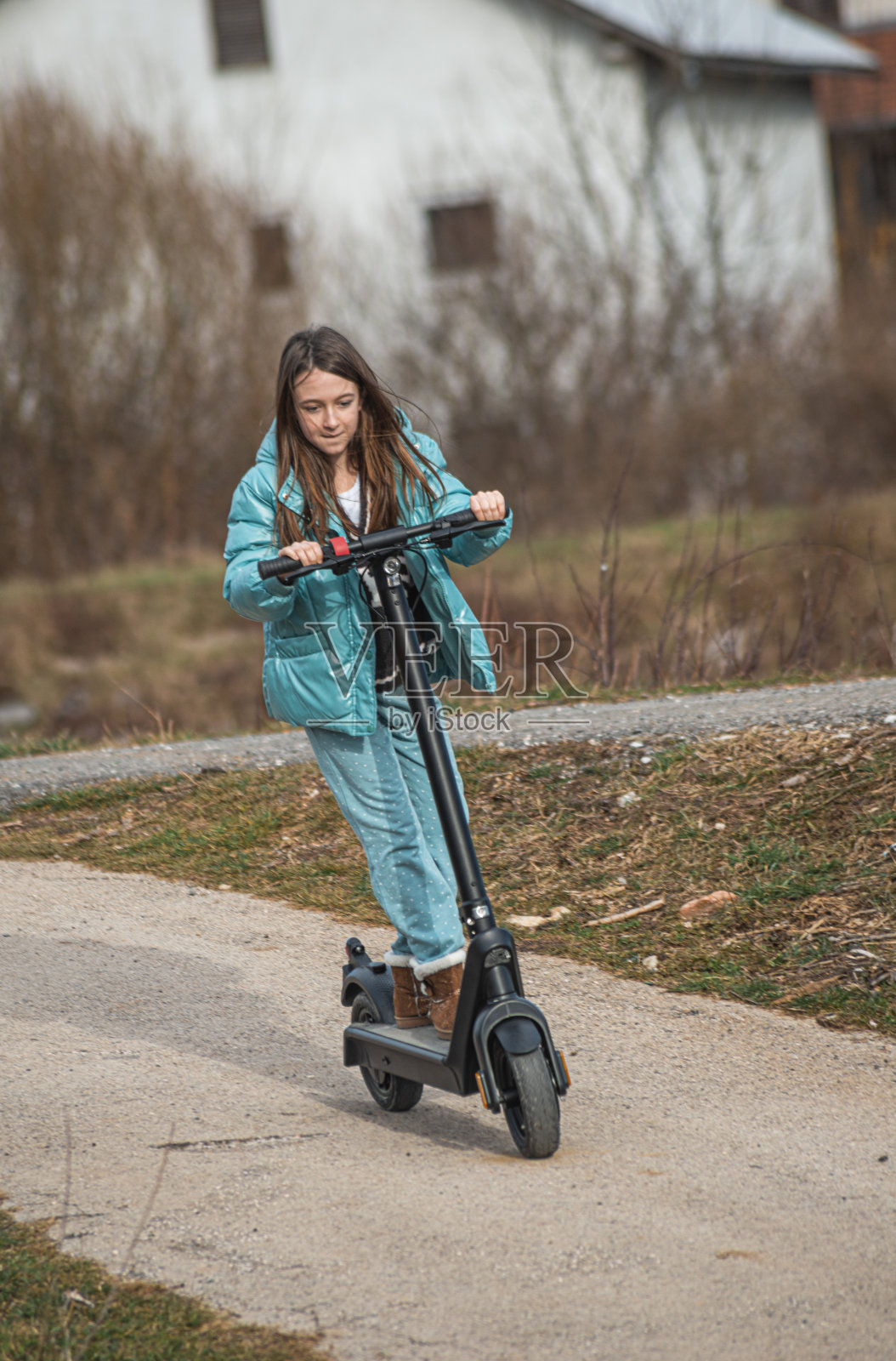 小女孩在城市人行道上玩滑板车照片摄影图片