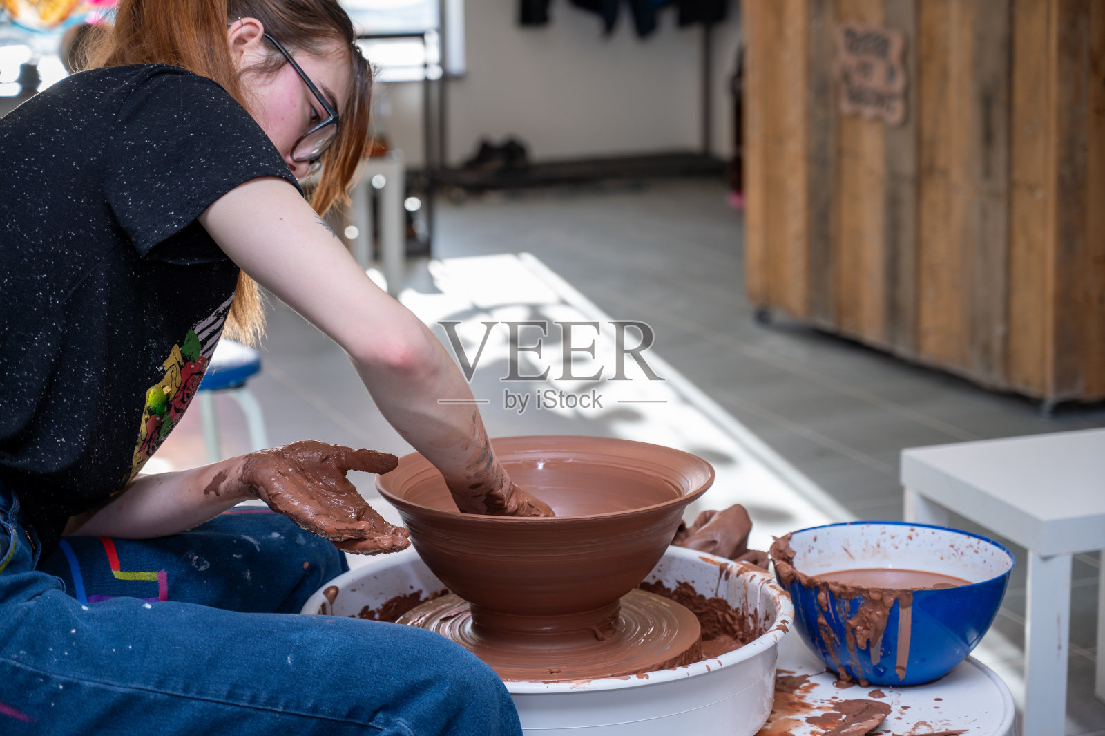 年轻女子的手在陶轮上照片摄影图片