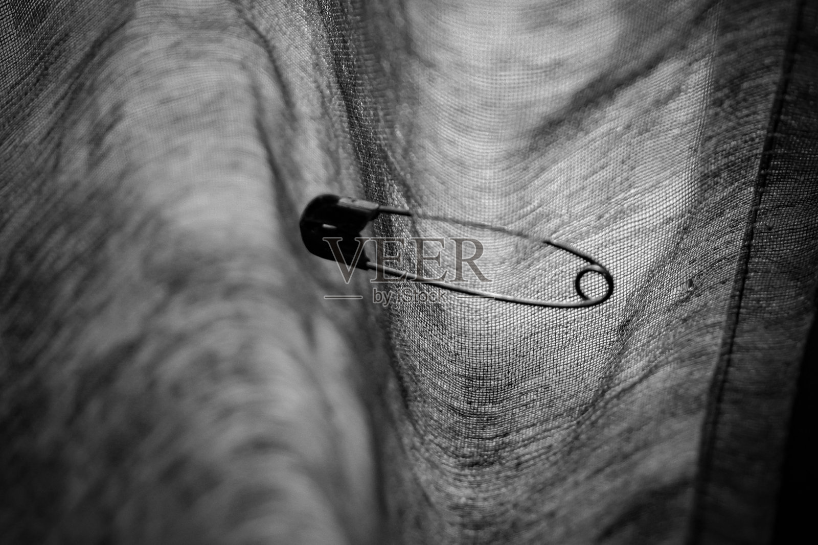 在布上的安全别针，安全别针钩在布上照片摄影图片