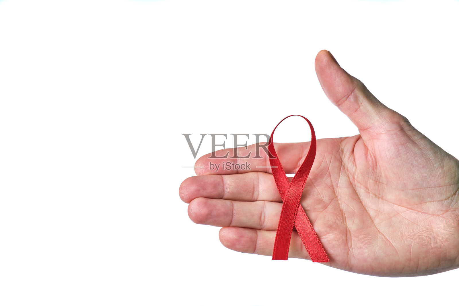 白底上系着抗击艾滋病的红丝带的男性手照片摄影图片