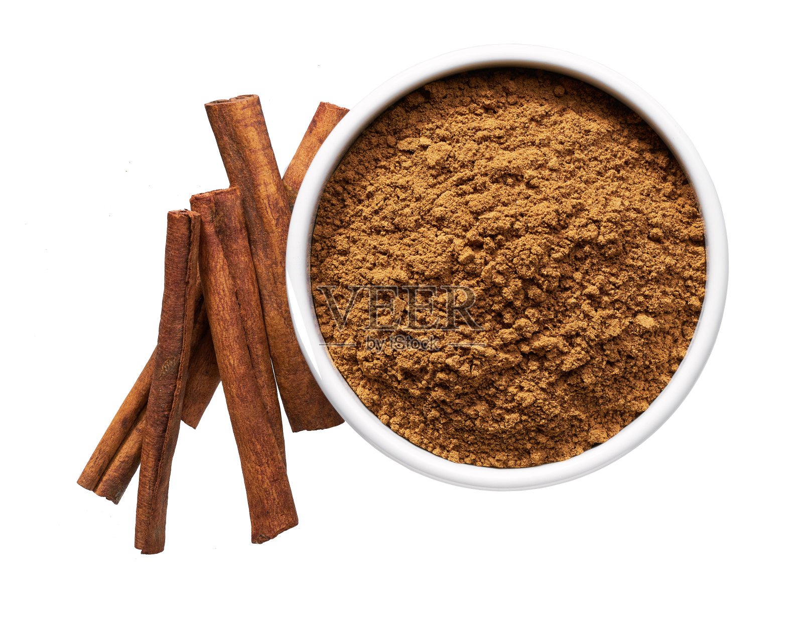 肉桂棒和陶瓷碗与肉桂粉隔离在一个白色的背景，俯视图。照片摄影图片