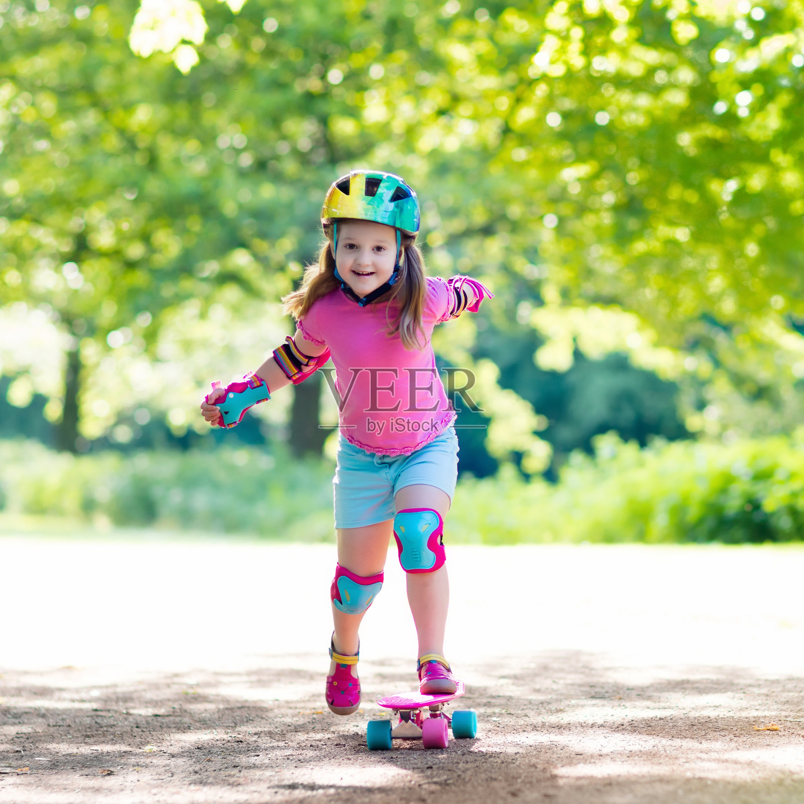 孩子在夏季公园玩滑板照片摄影图片