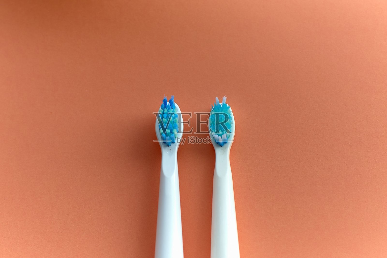 橙色背景上的两把牙刷照片摄影图片