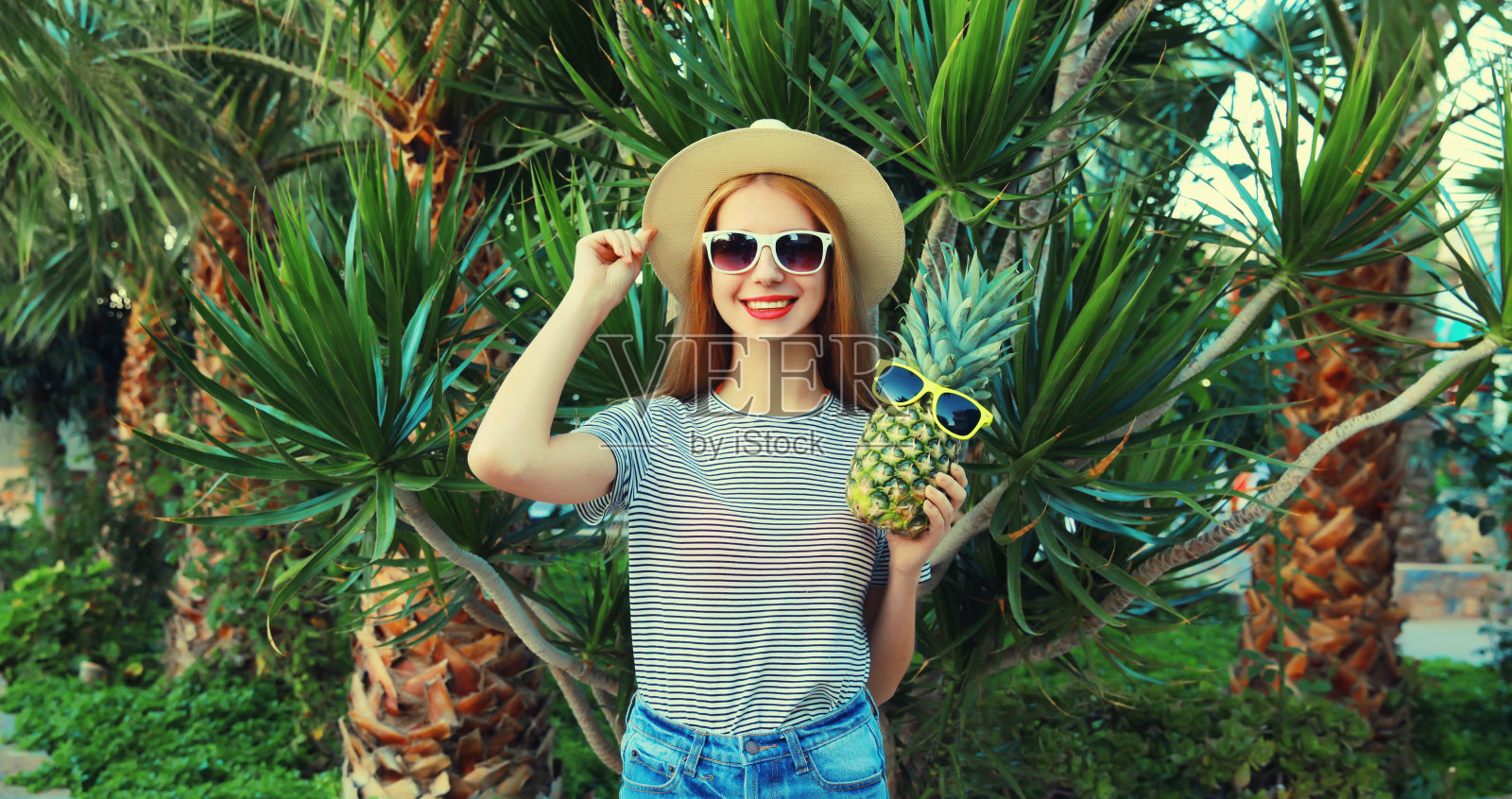 夏天快乐的年轻女子与菠萝水果在棕榈树的背景照片摄影图片