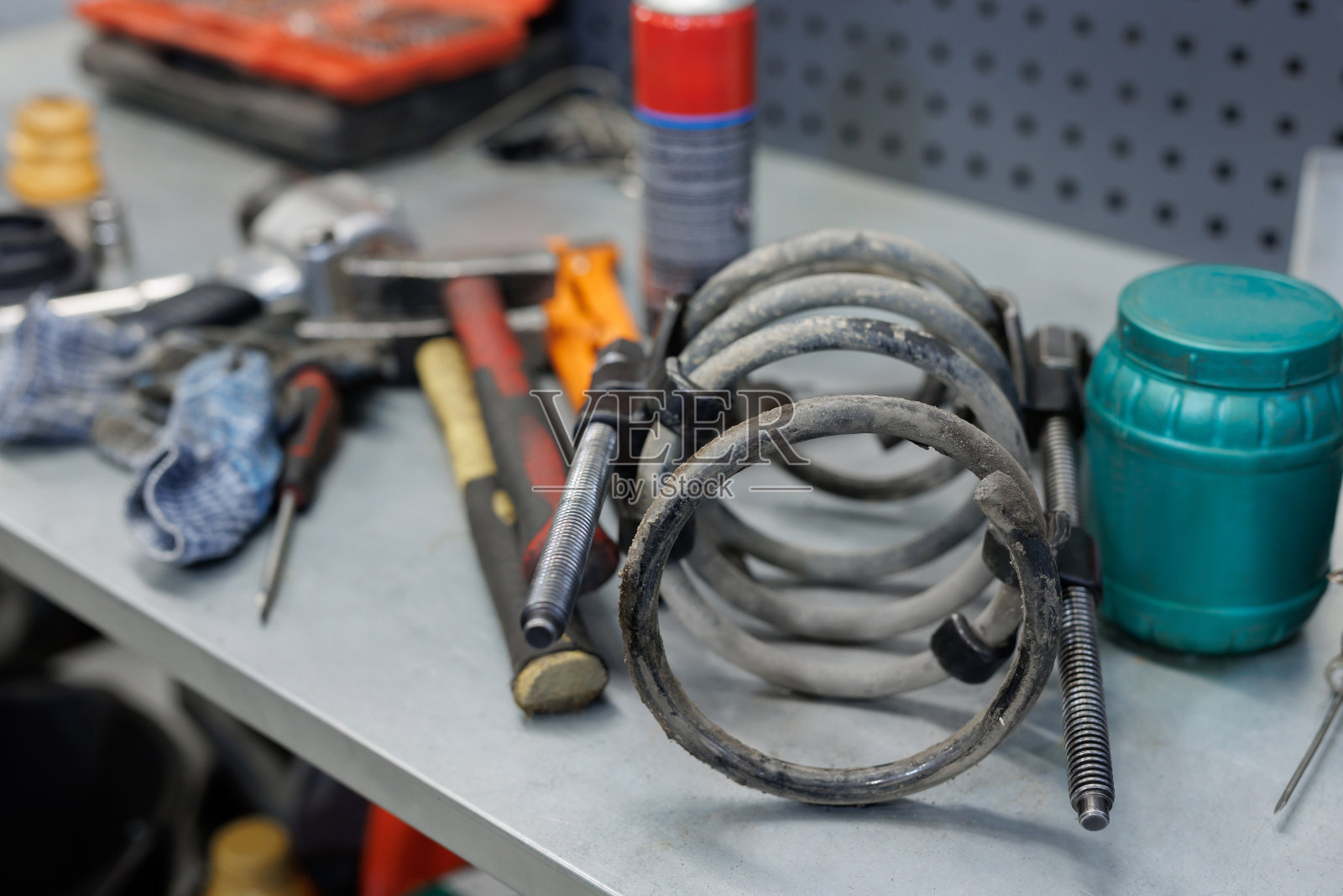 汽车零配件。在服务中心更换乘用车前弹簧和减震器。汽车维修站的维修和保养。照片摄影图片