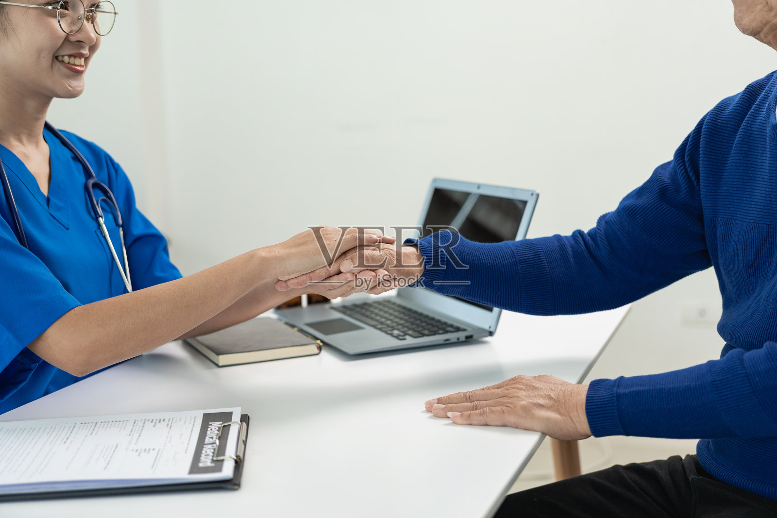 亚洲专业女医生在保健院诊疗室的桌子上，与男病人谈论他的疼痛和症状照片摄影图片