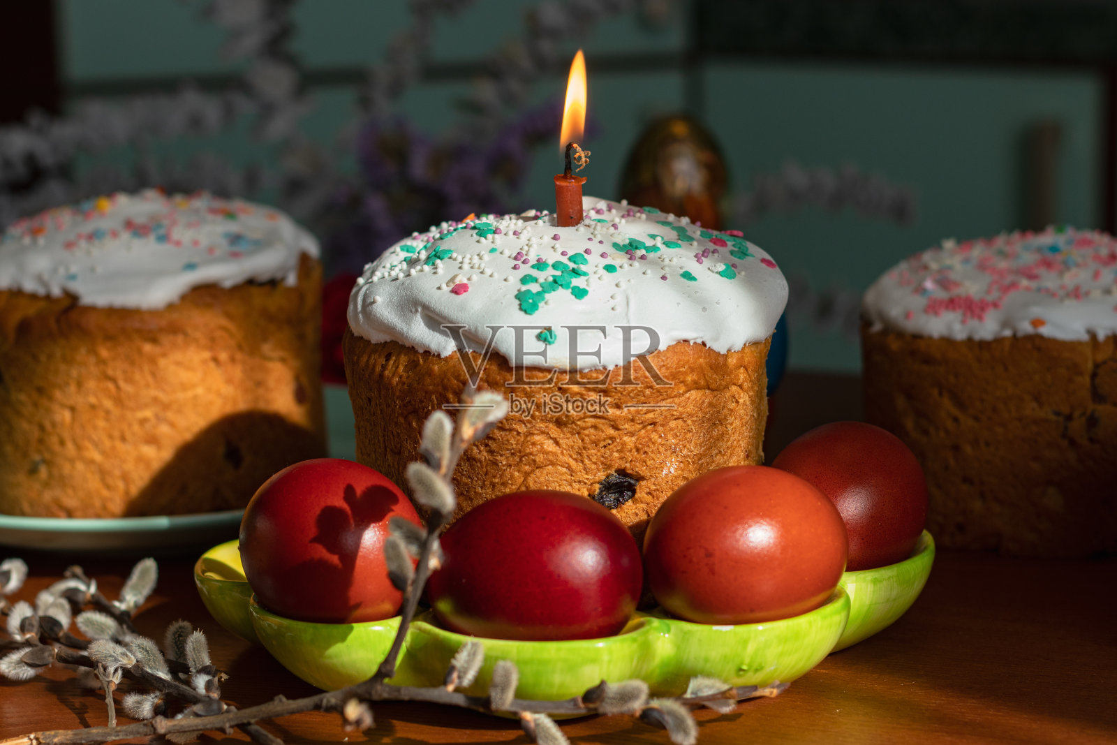 餐桌上优雅的复活节蛋糕和燃烧的蜡烛照片摄影图片