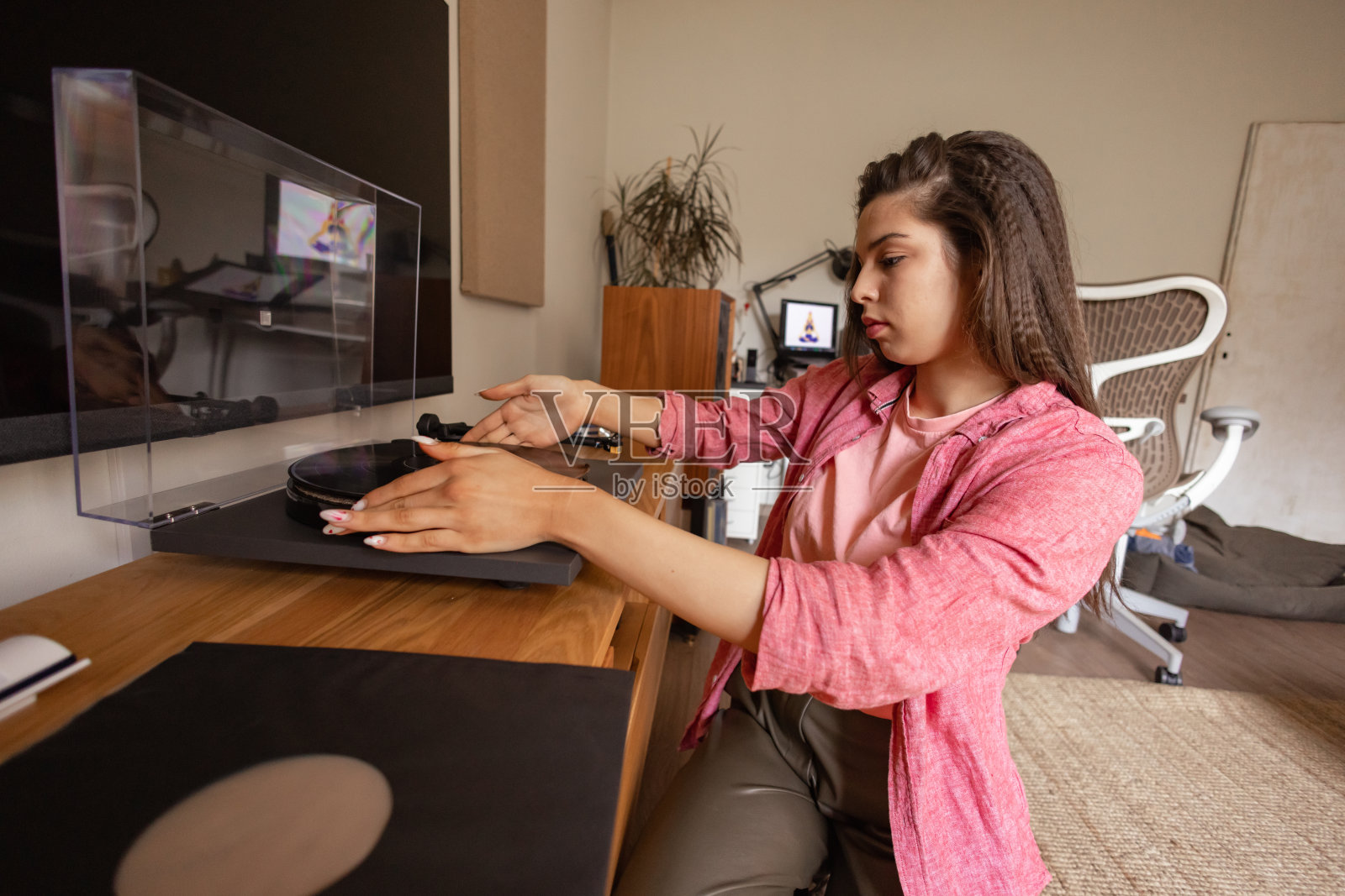年轻女士在她的生活空间享受黑胶唱片照片摄影图片