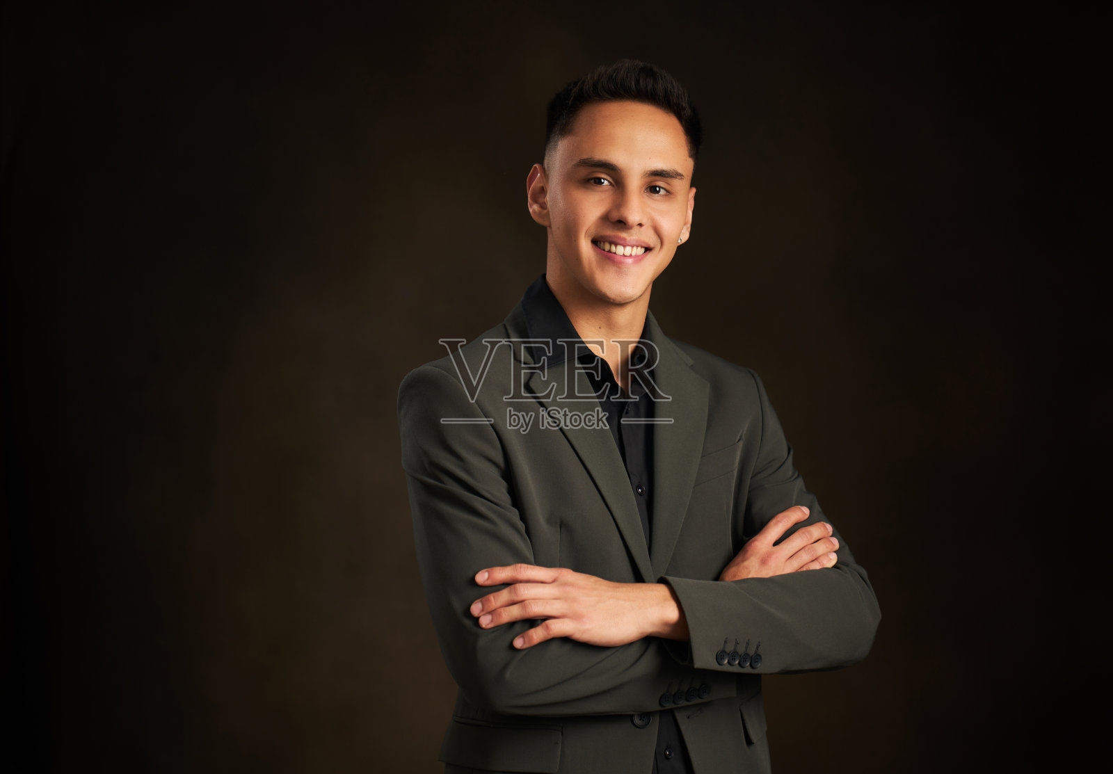 一个穿西装的男人双臂交叉，面带微笑照片摄影图片