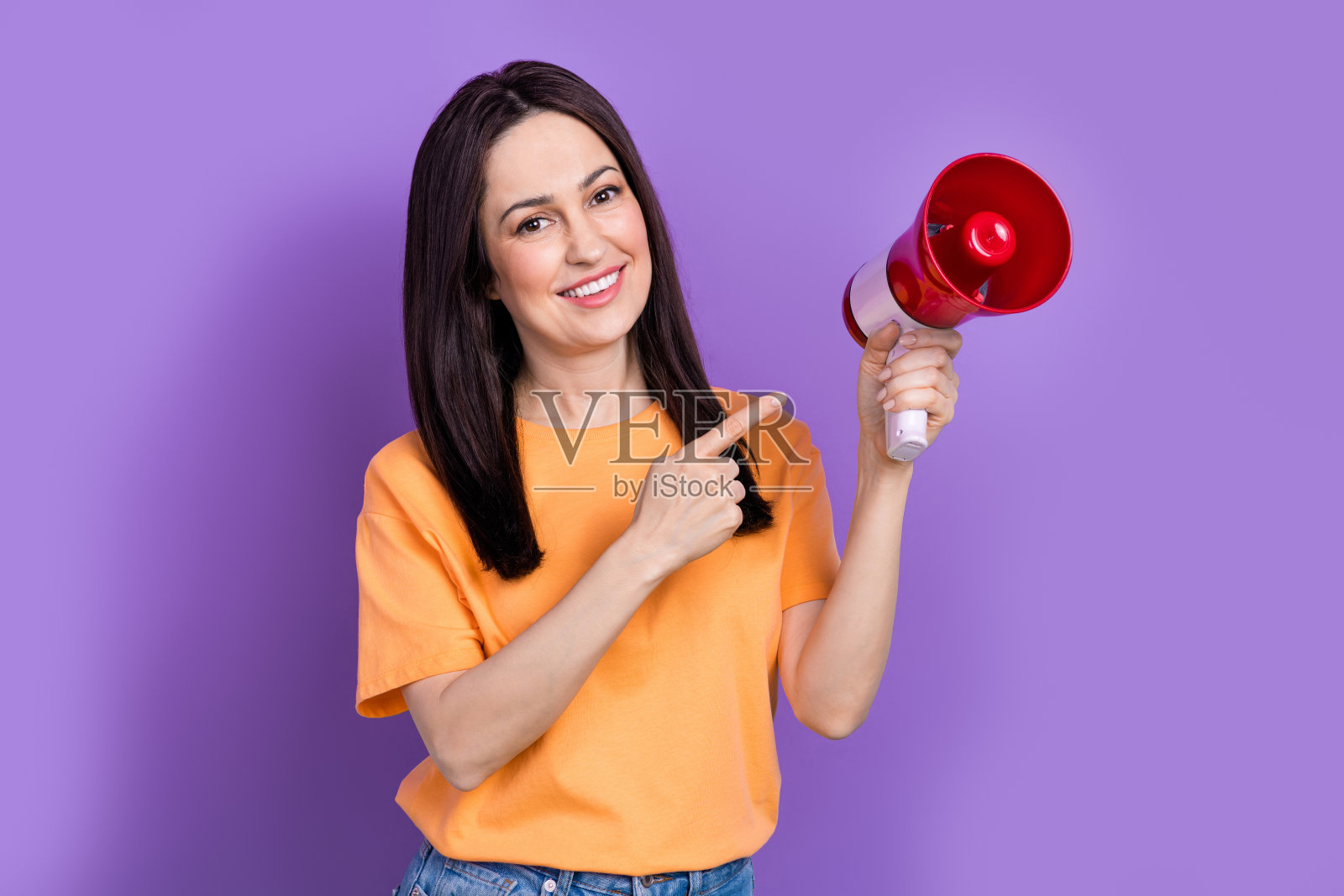 成熟年龄的照片黑发女商人测试她的扩音器直接手指推广扬声器隔离在紫色的背景照片摄影图片