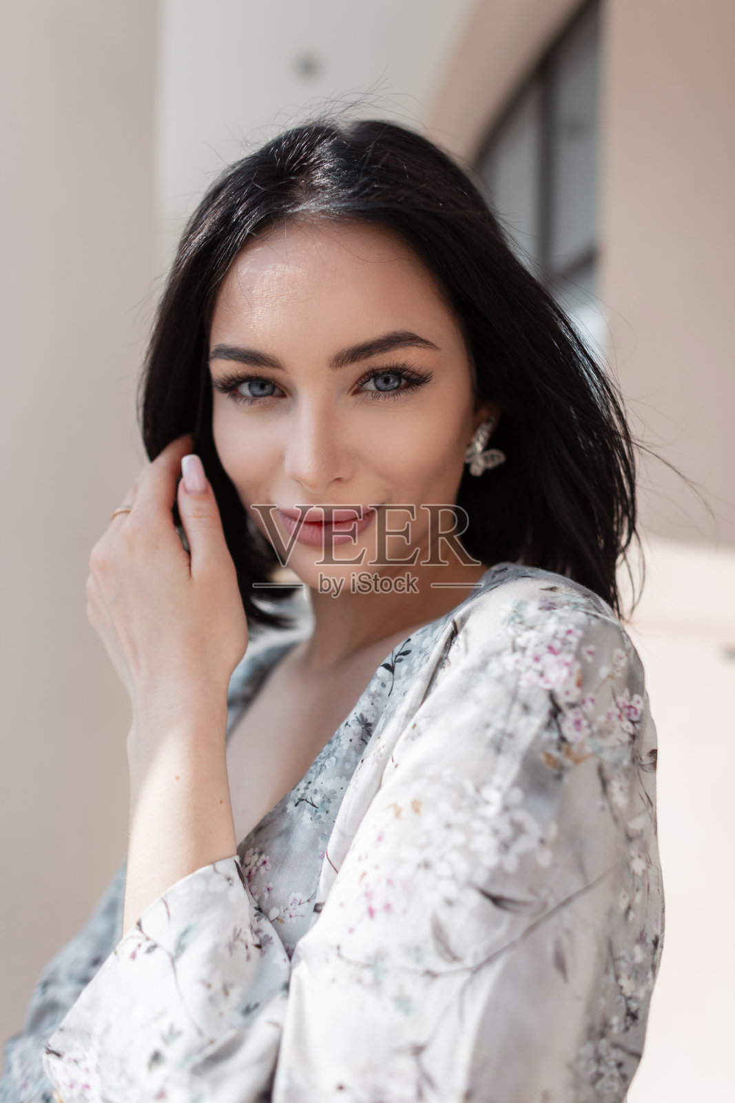 美丽新潮的年轻女子，梳着波波头，穿着时尚的春季碎花连衣裙，在夏日阳光明媚的日子里走在城市的古建筑附近。照片摄影图片