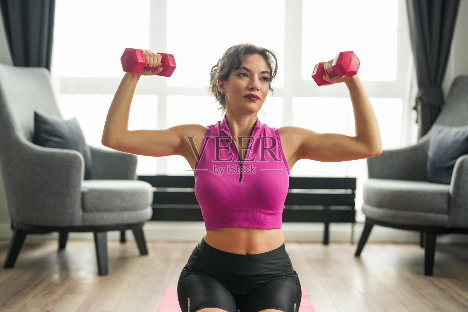 年轻漂亮的女人在家里的垫子上做运动照片摄影图片