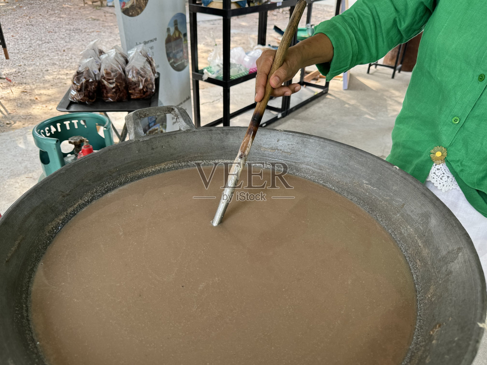亚洲农村妇女带来虾酱，这是一种亚洲调味品，将其捣碎，然后在平底锅中烘烤，这是一种保存食物的方法，可以保存得更久。虾酱是一种泰国食品原料，虾酱是用虾做成的。商店照片摄影图片