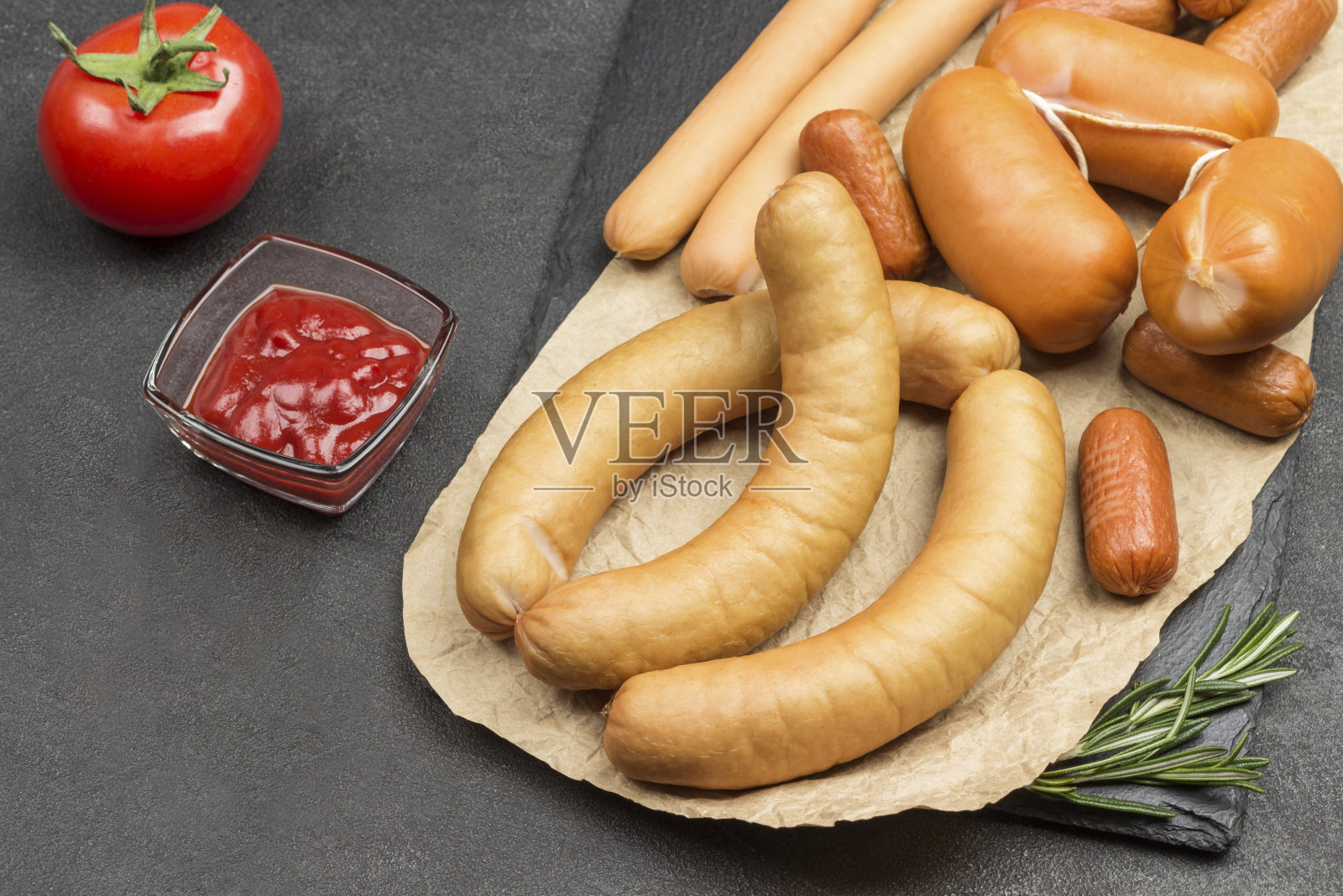 不同品种的香肠放在纸上。照片摄影图片