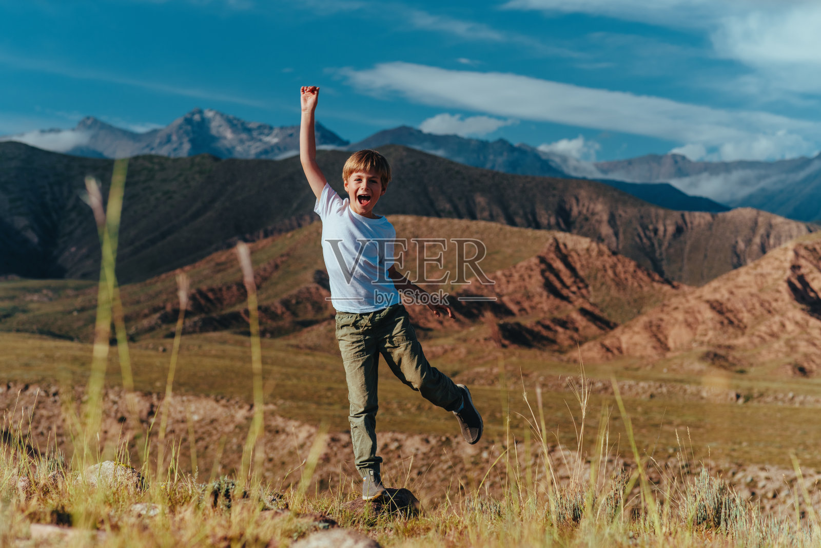 快乐的男孩在山上玩照片摄影图片