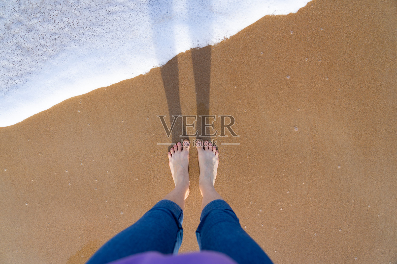 女人的脚踩在海边照片摄影图片