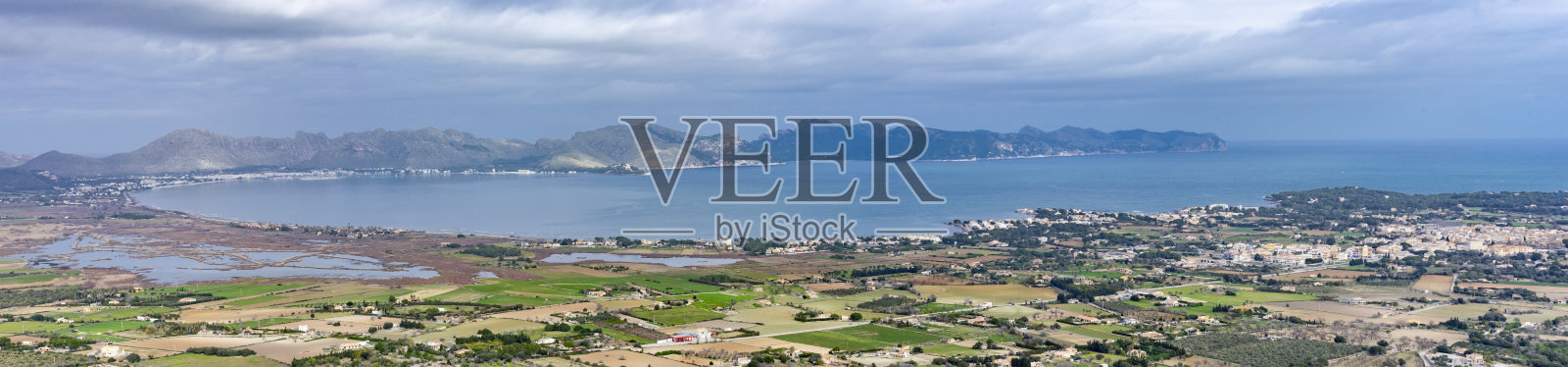 马略卡岛的波伦萨湾全景与沿海城镇和山脉的背景照片摄影图片
