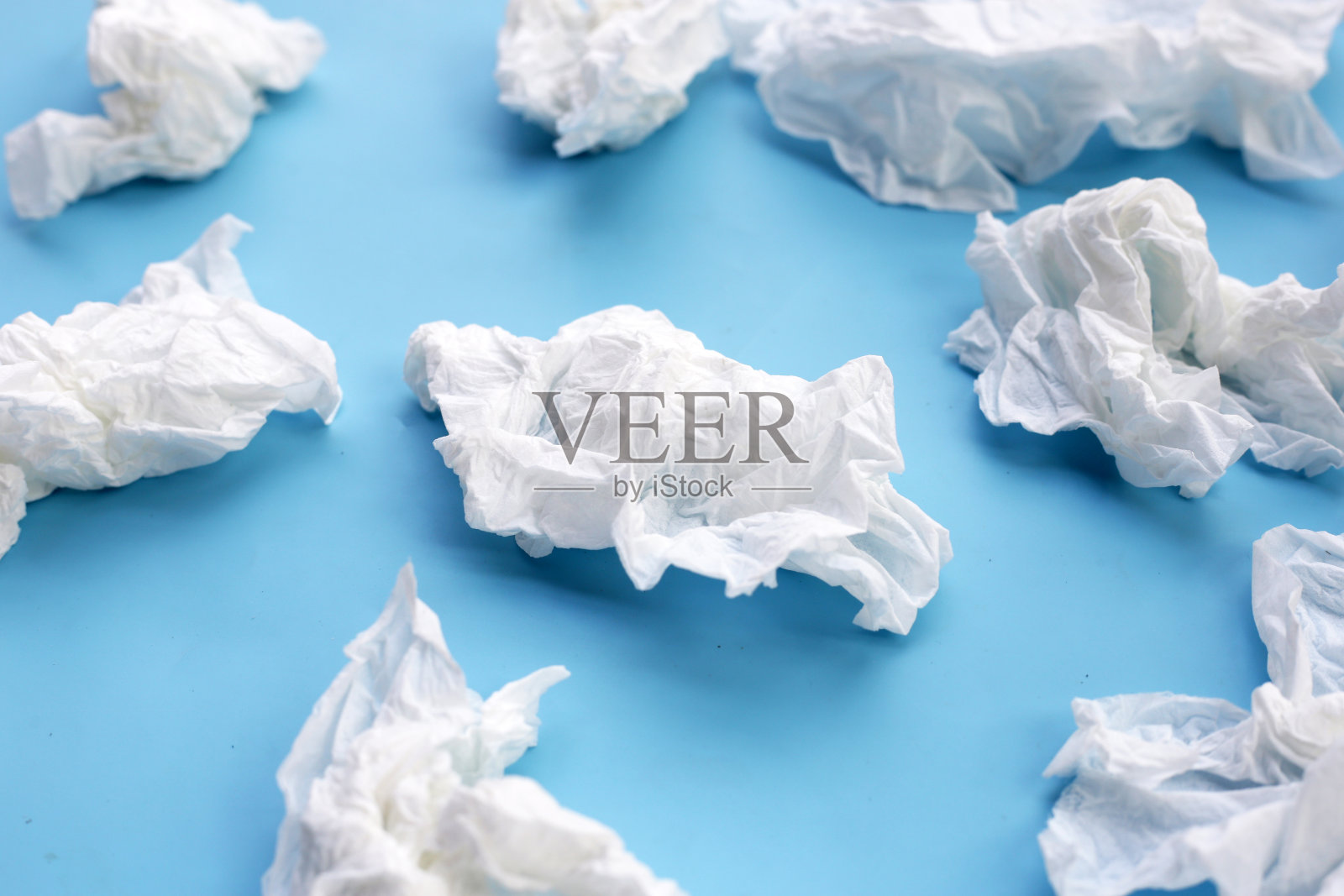 揉皱的薄纸。蓝色背景的面巾纸。照片摄影图片
