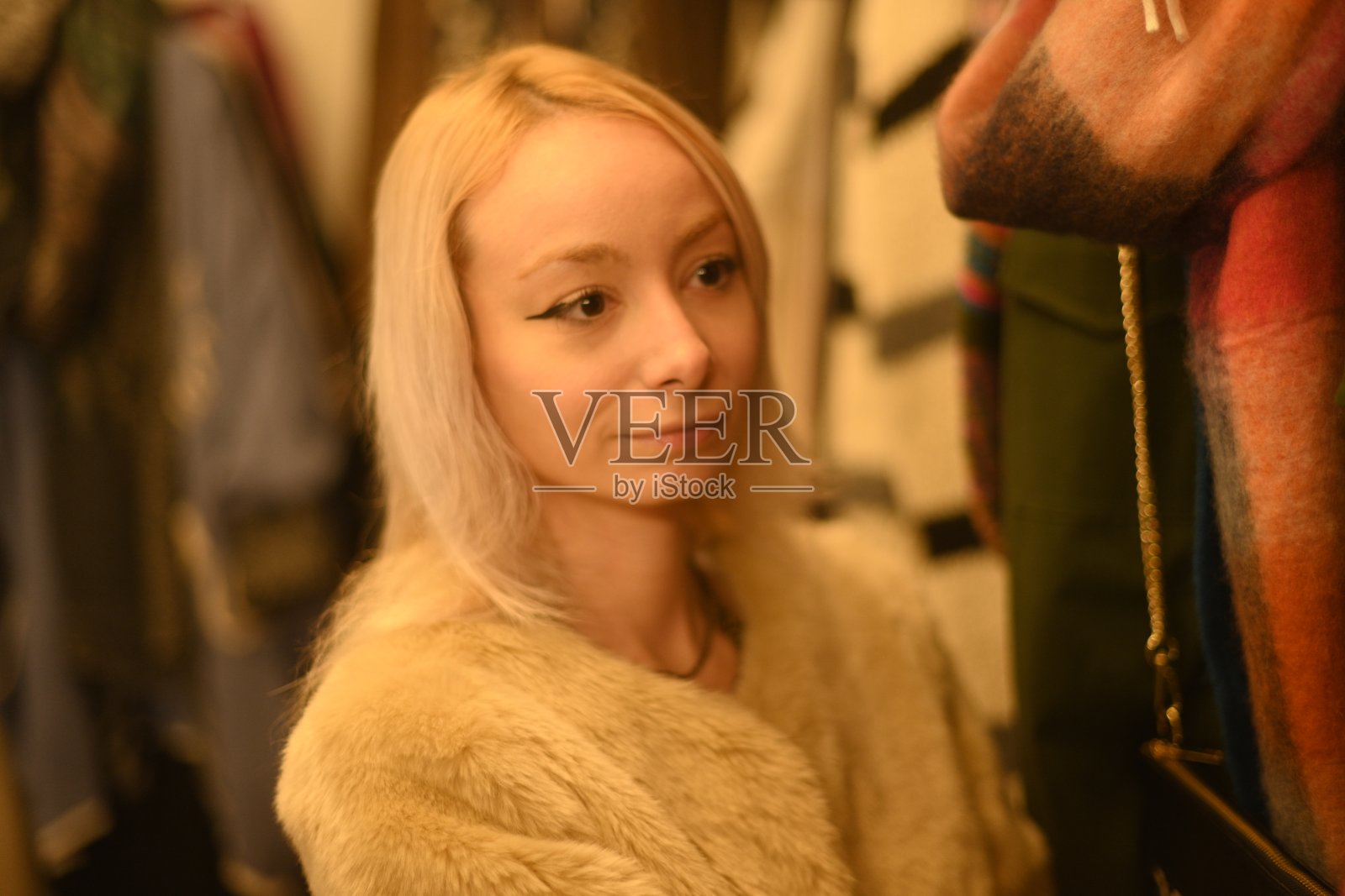 金发碧眼的年轻女子和红头发的好朋友在时装店挑选冬季打折的衣服照片摄影图片