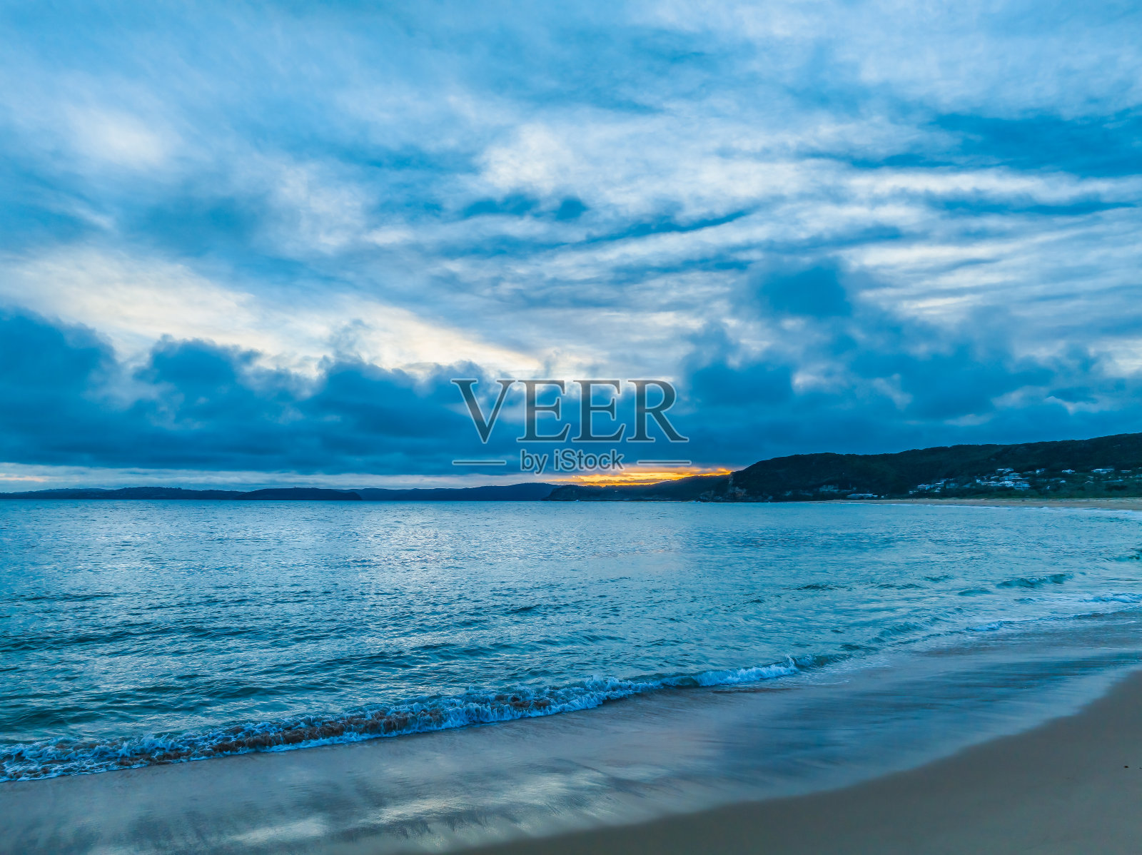 大海和沙滩上的高云日落照片摄影图片