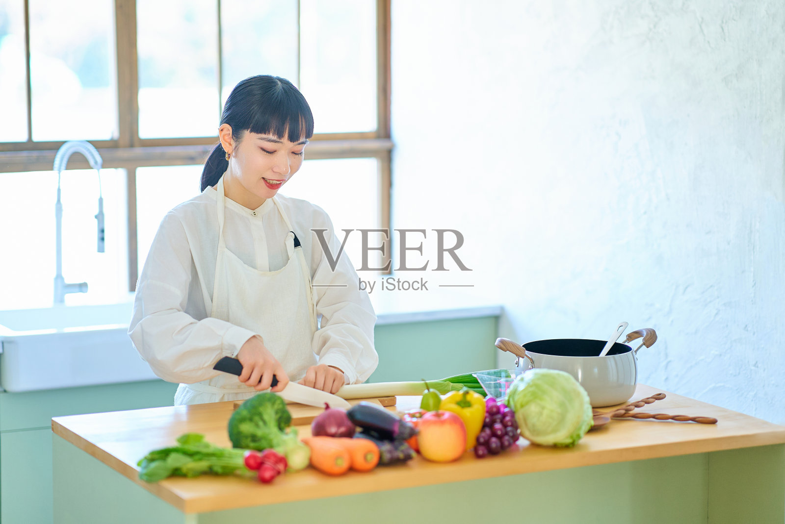 年轻女子用刀切食材照片摄影图片