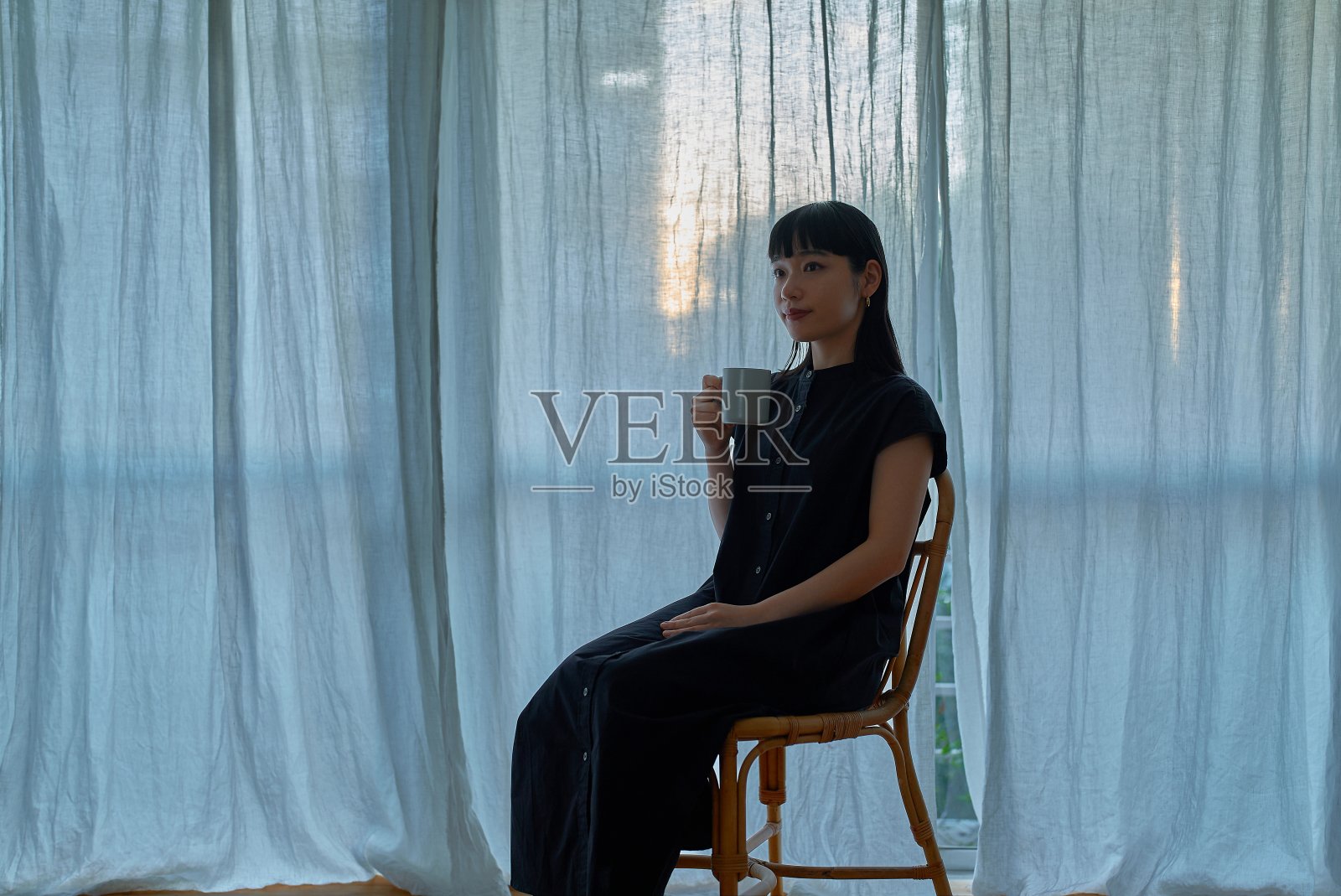 一位年轻女子在窗边休息照片摄影图片