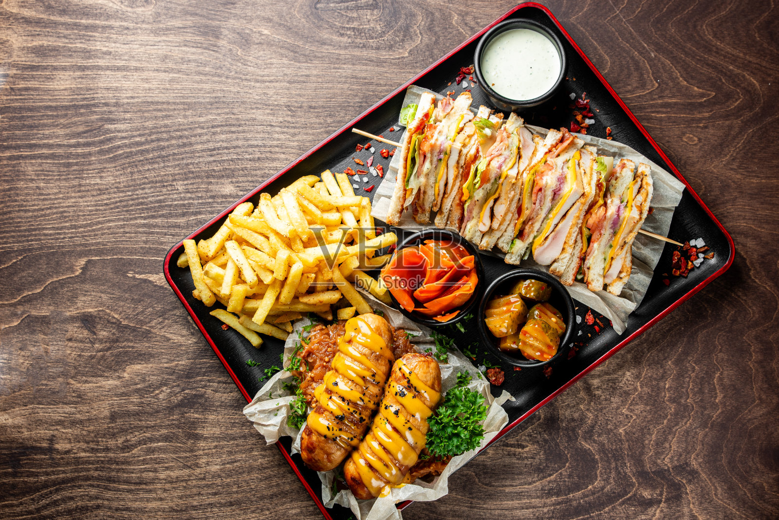 盘子里的快餐。肉烤香肠，三明治，薯条和蔬菜照片摄影图片