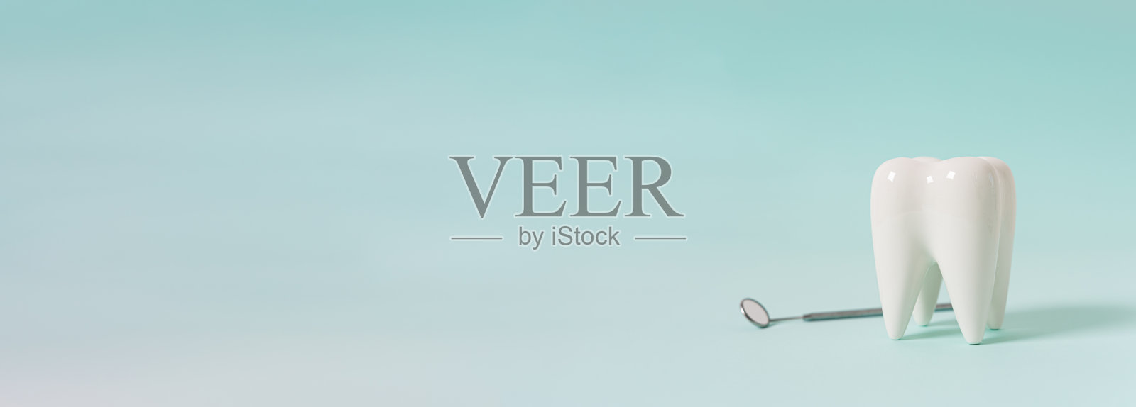 牙科诊所特别优惠横幅。健康的白牙模型和蓝色背景的牙医镜子。副本的空间。牙齿护理和美白网线，牙科治疗，拔牙，种植概念。照片摄影图片